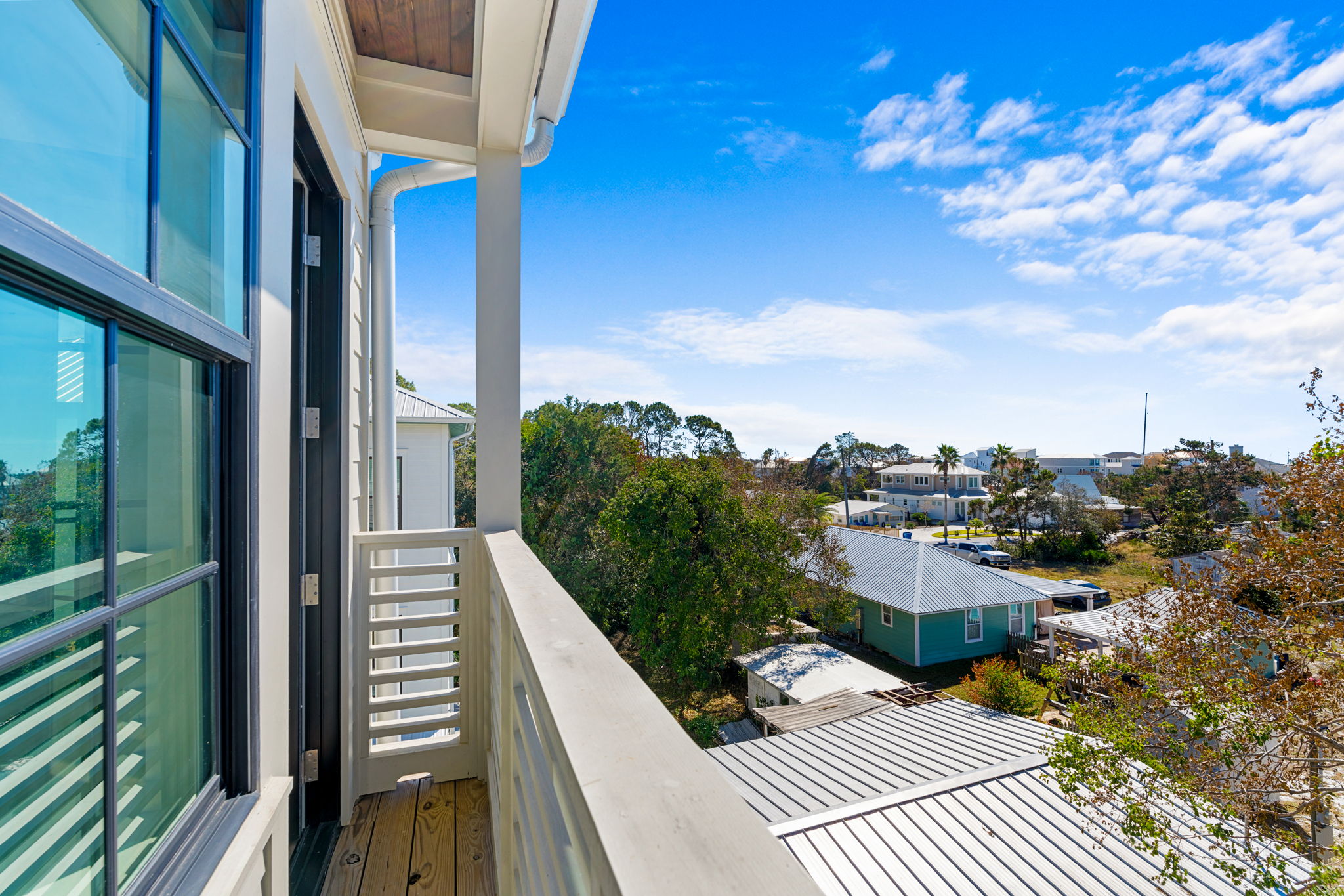 Private balcony with sunny neighborhood views and coastal charm