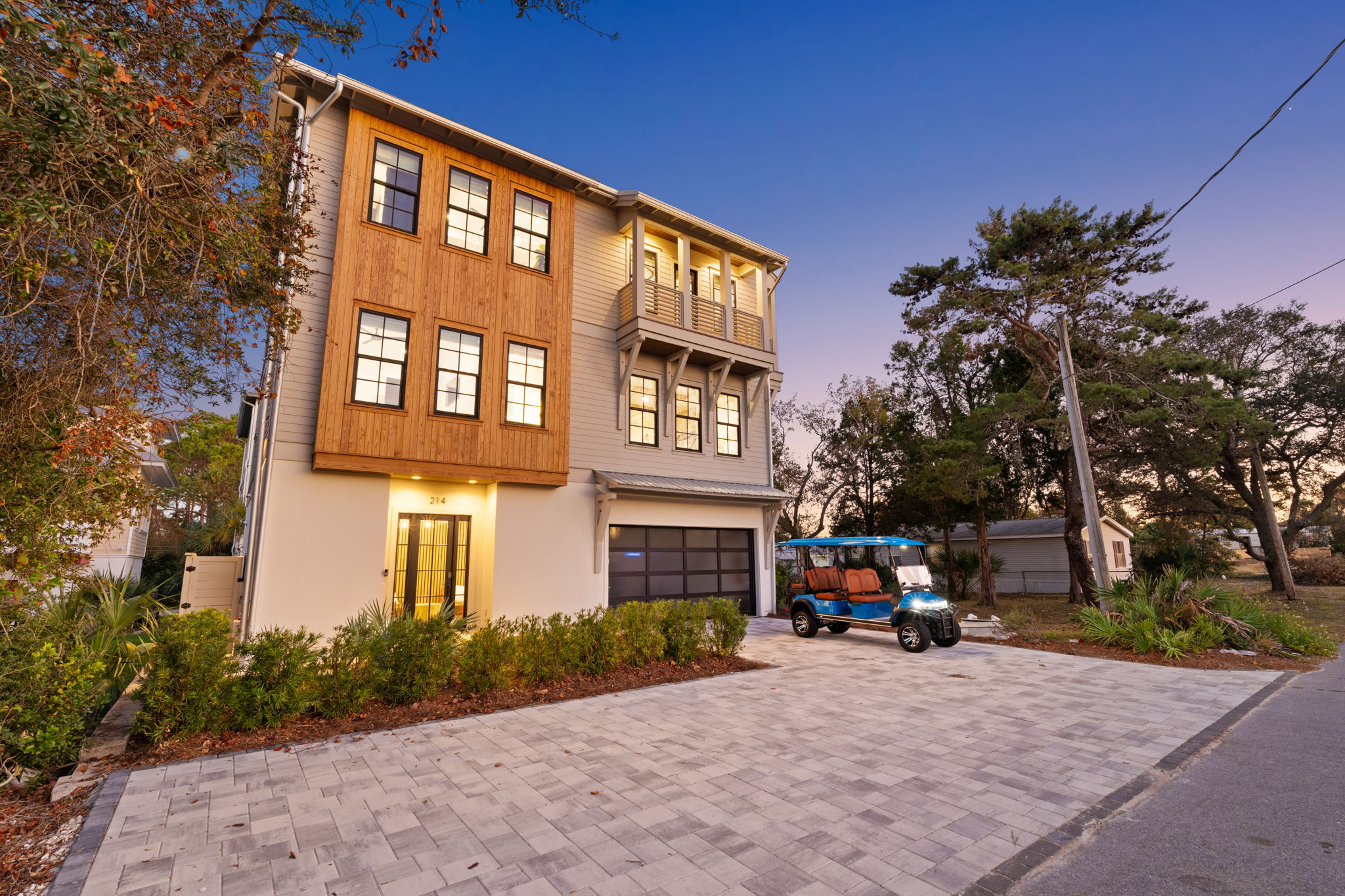 Stylish coastal home with spacious driveway, garage, and golf cart