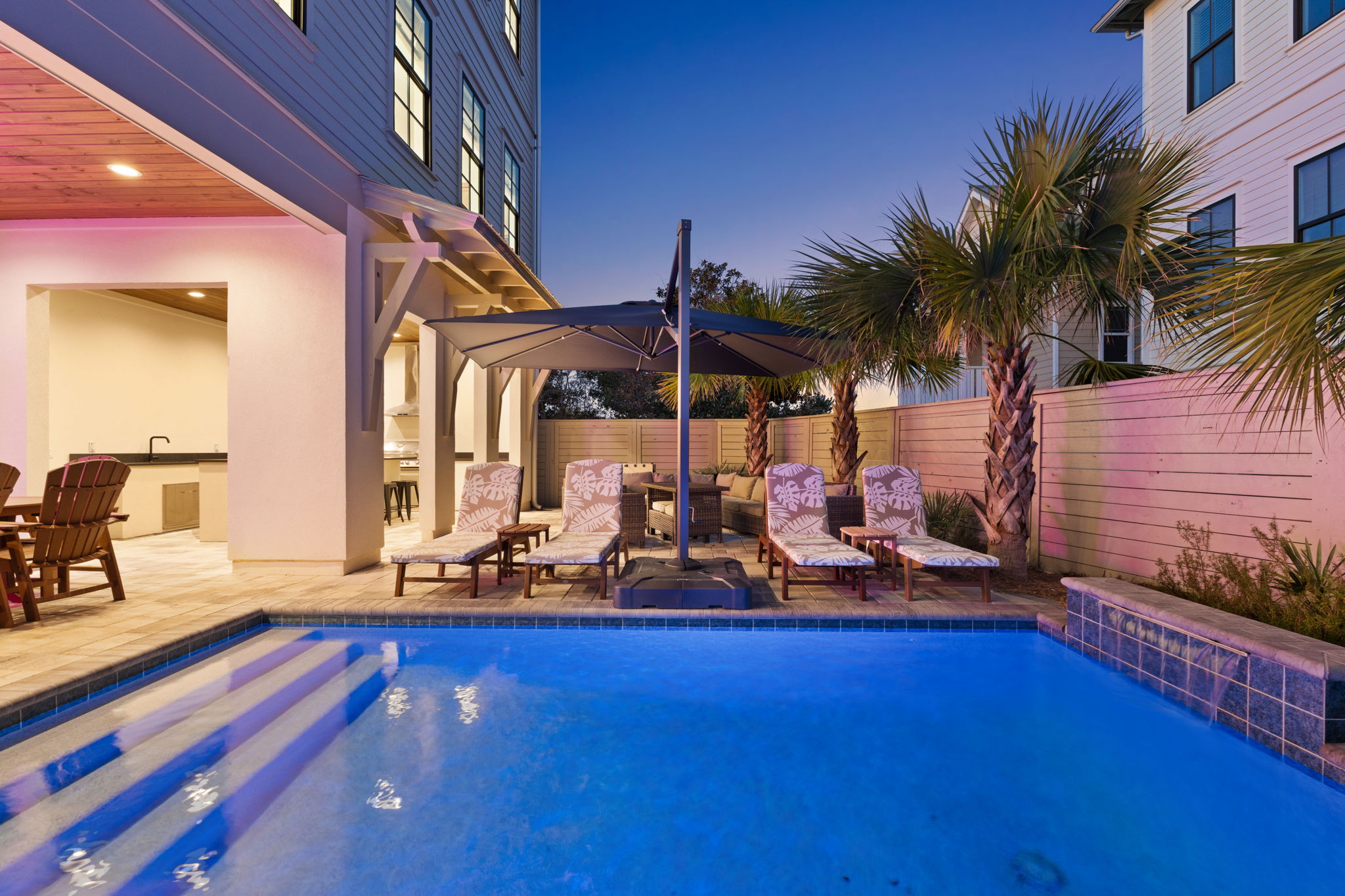 Private resort-style pool with palm trees, loungers & covered patio