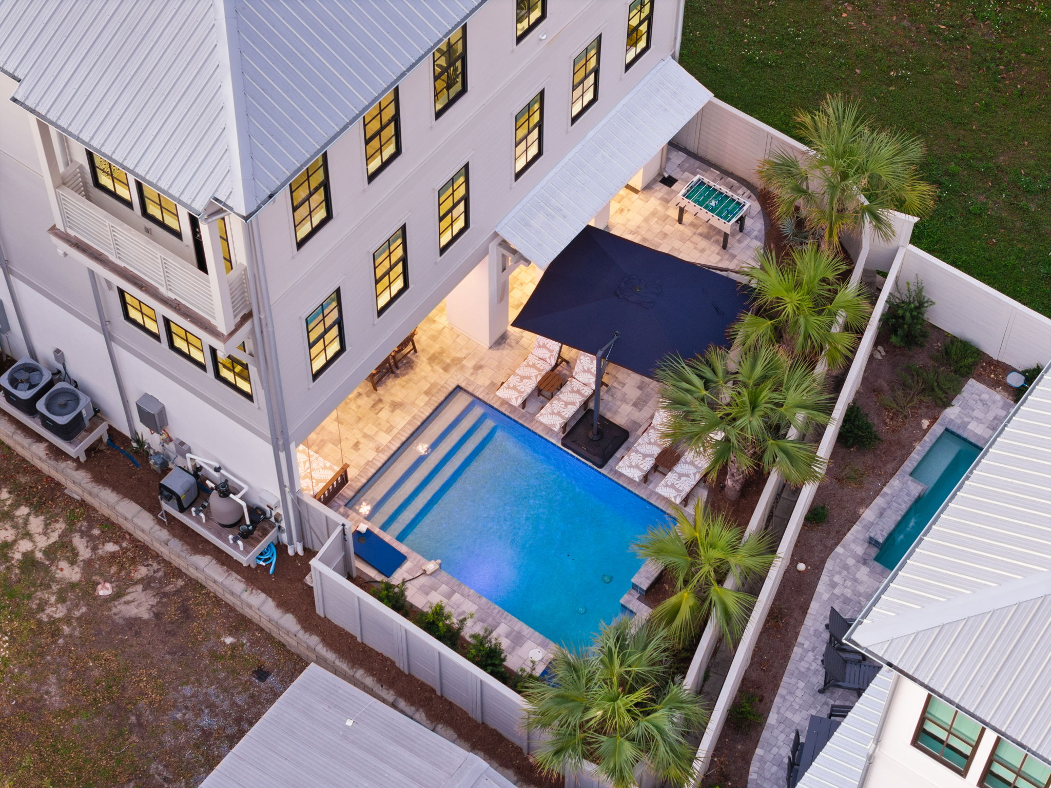 Private resort-style pool courtyard with palms, lounge seating & hot tub