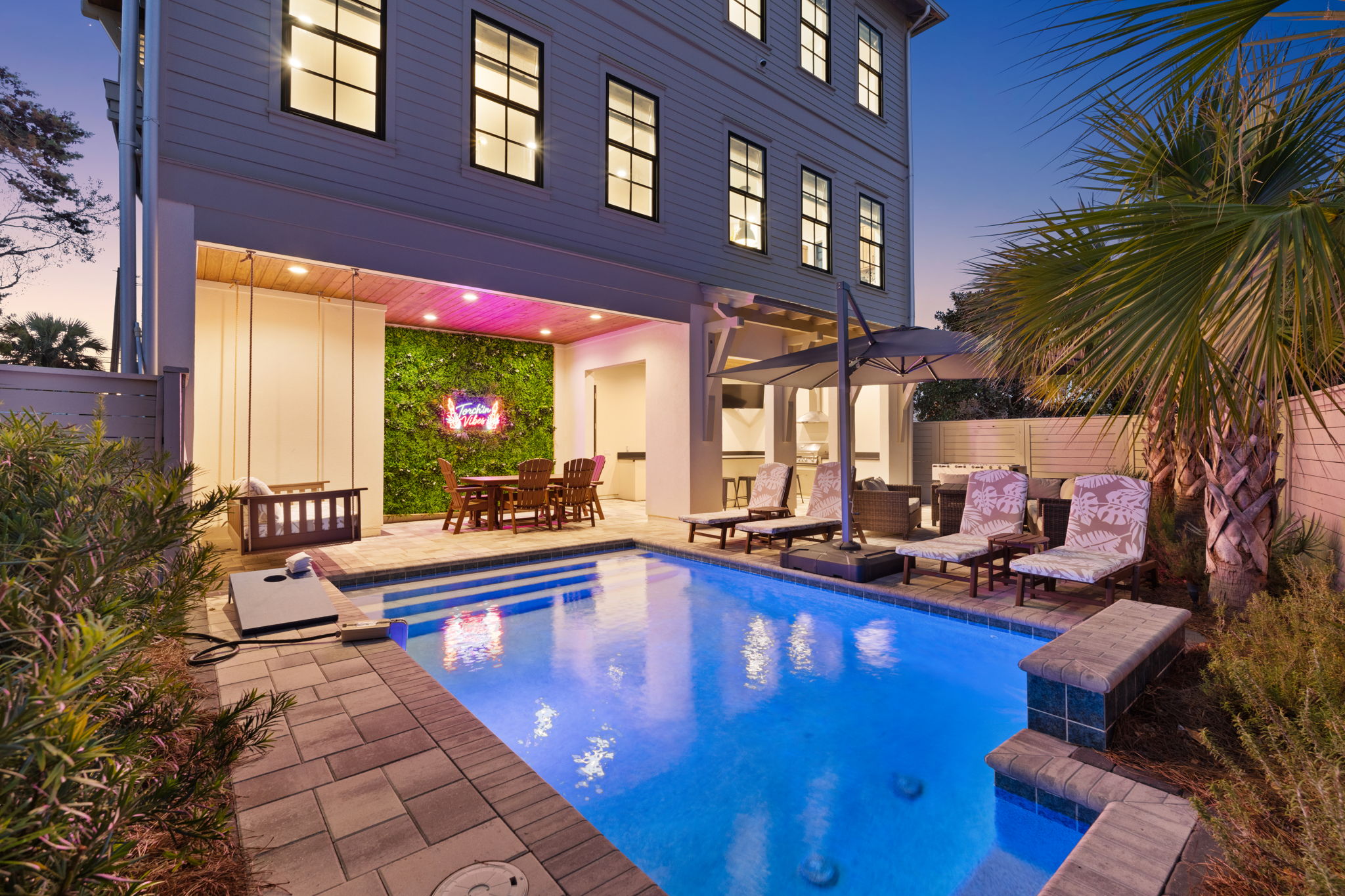 Private pool oasis with lounge seating, covered patio, and evening ambiance