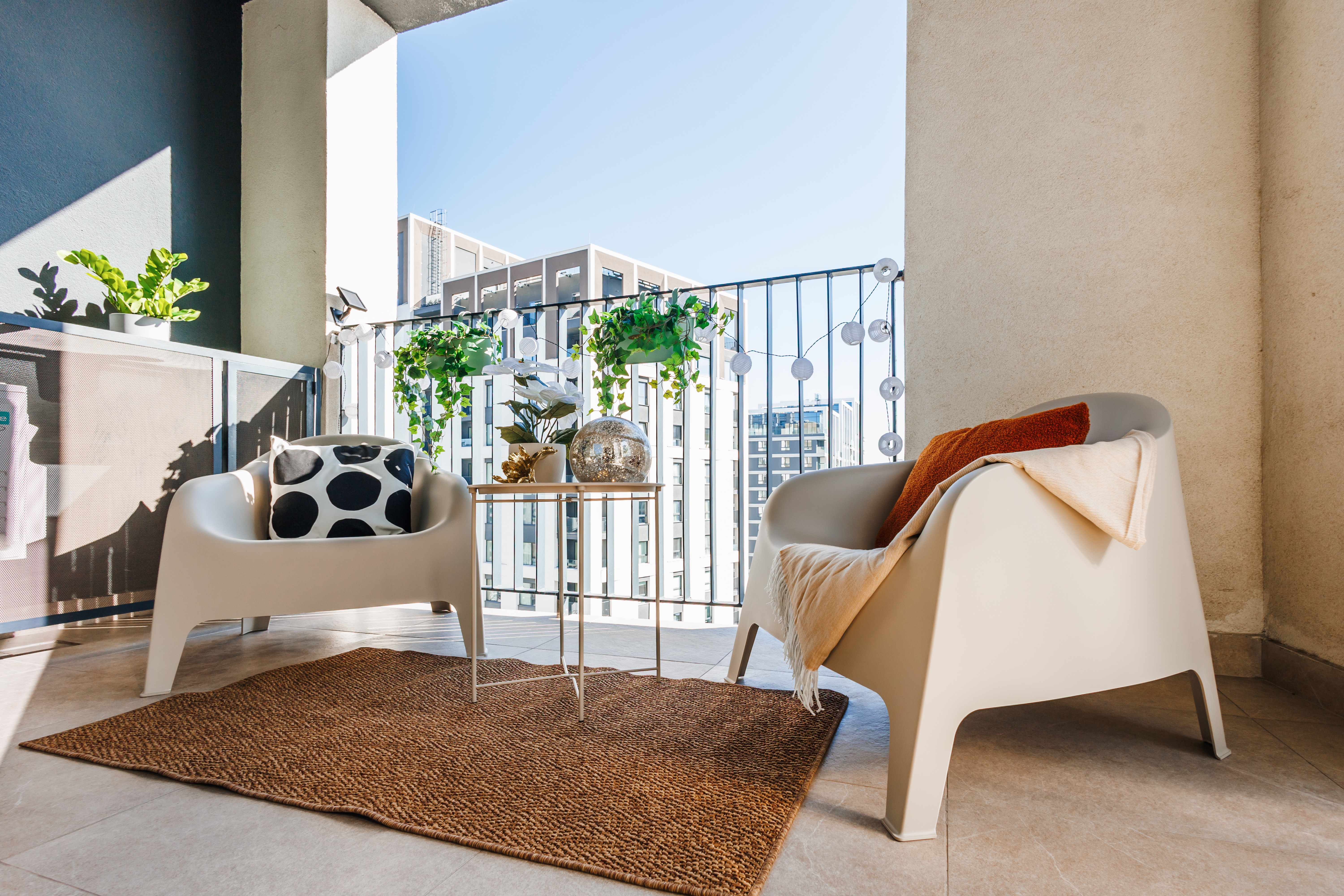 Sunny city-view balcony with stylish seating and cozy outdoor charm