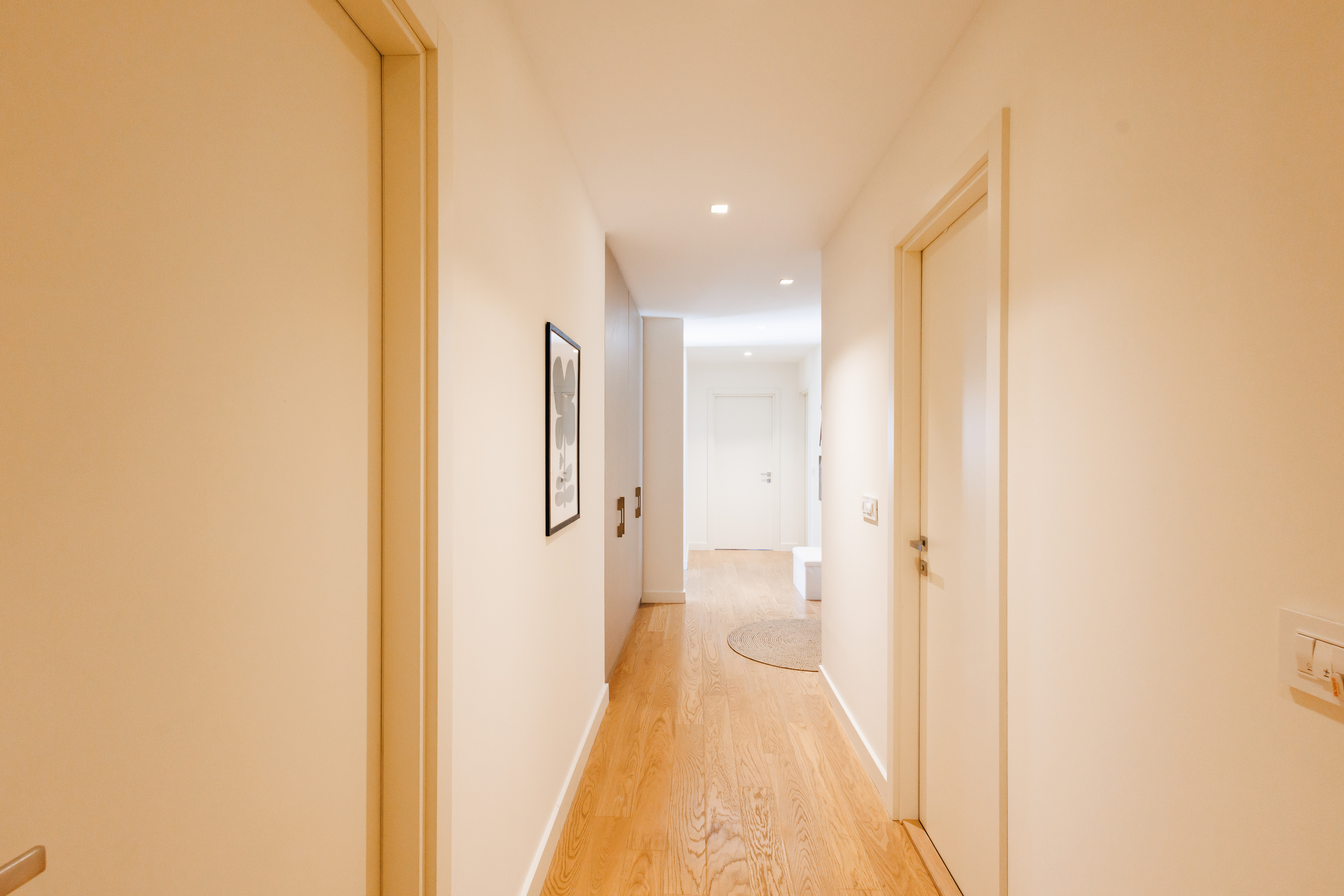 Bright modern hallway with warm wood floors and sleek minimalist design