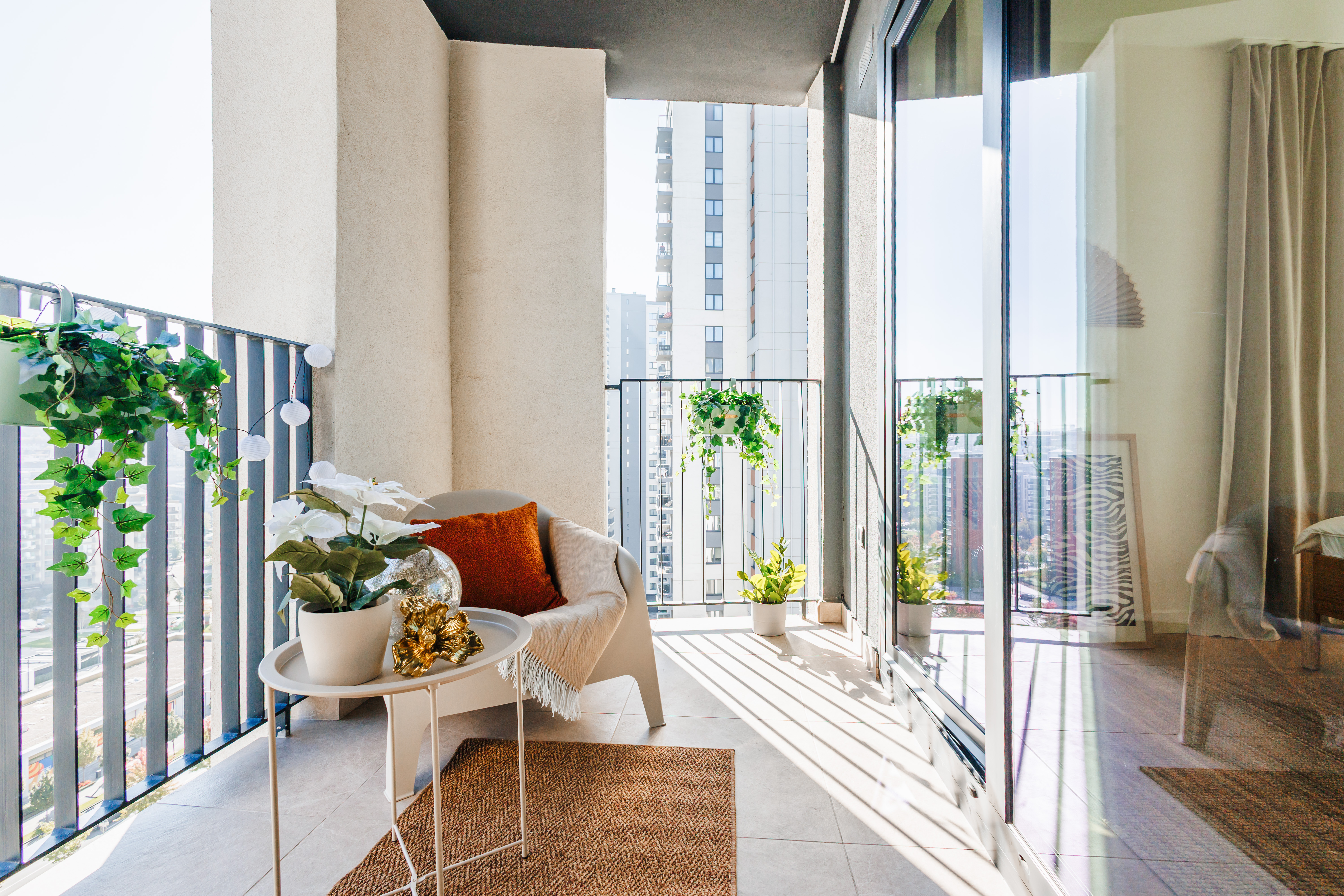 Sunny private balcony with cozy seating and elevated city views