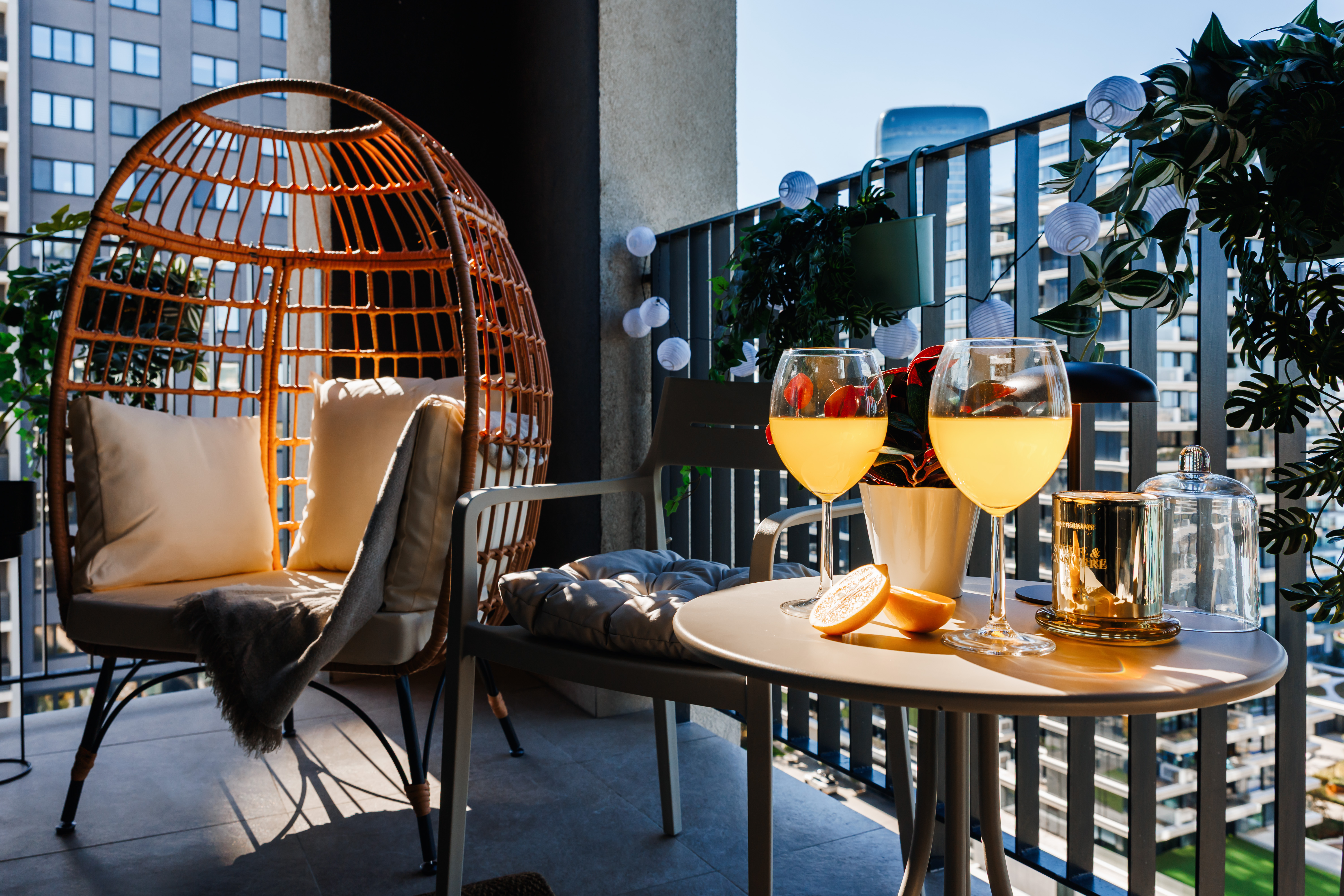 Cozy city-view balcony with egg chair, wine, and inviting lounge seating