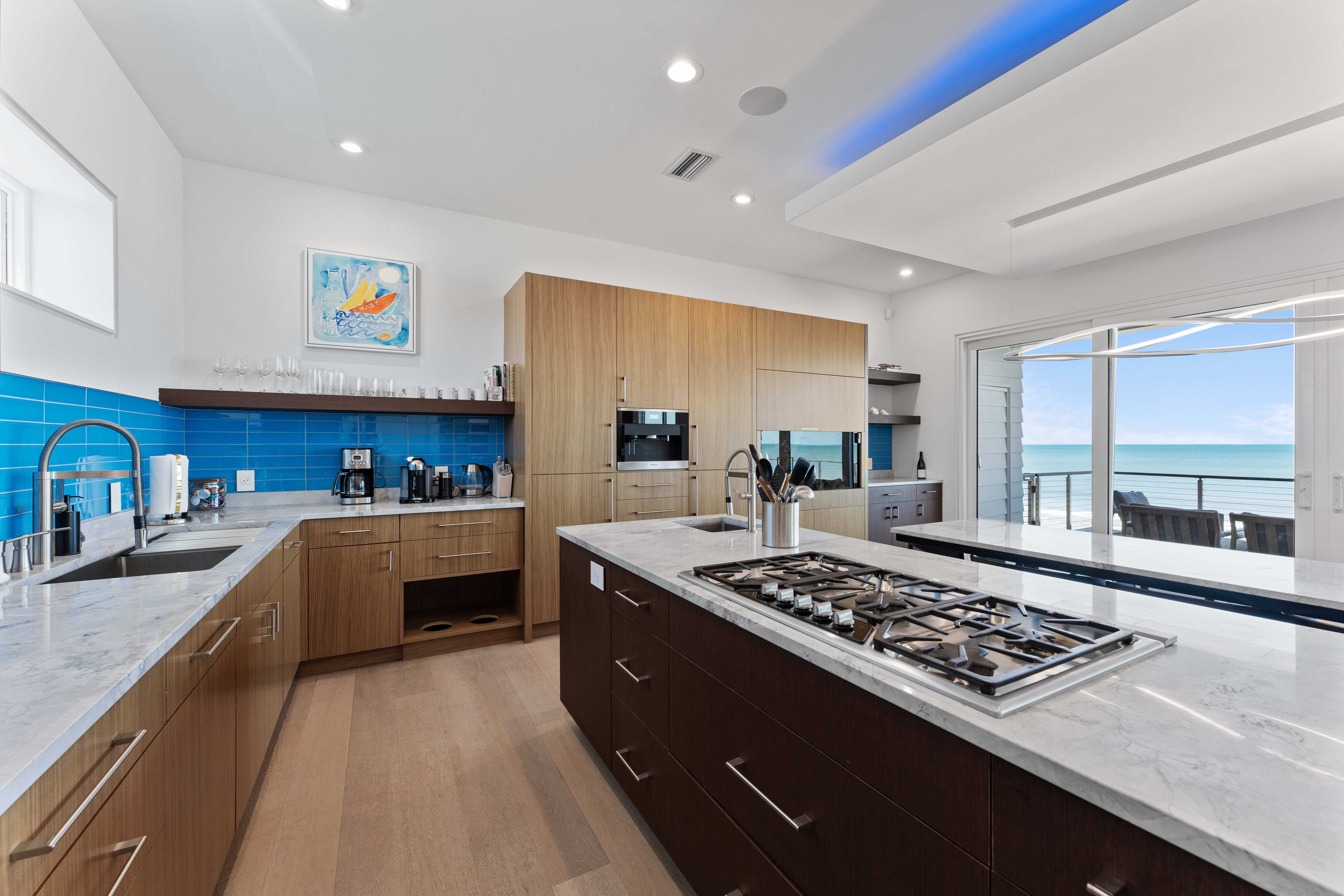 Modern gourmet kitchen with ocean-view balcony access