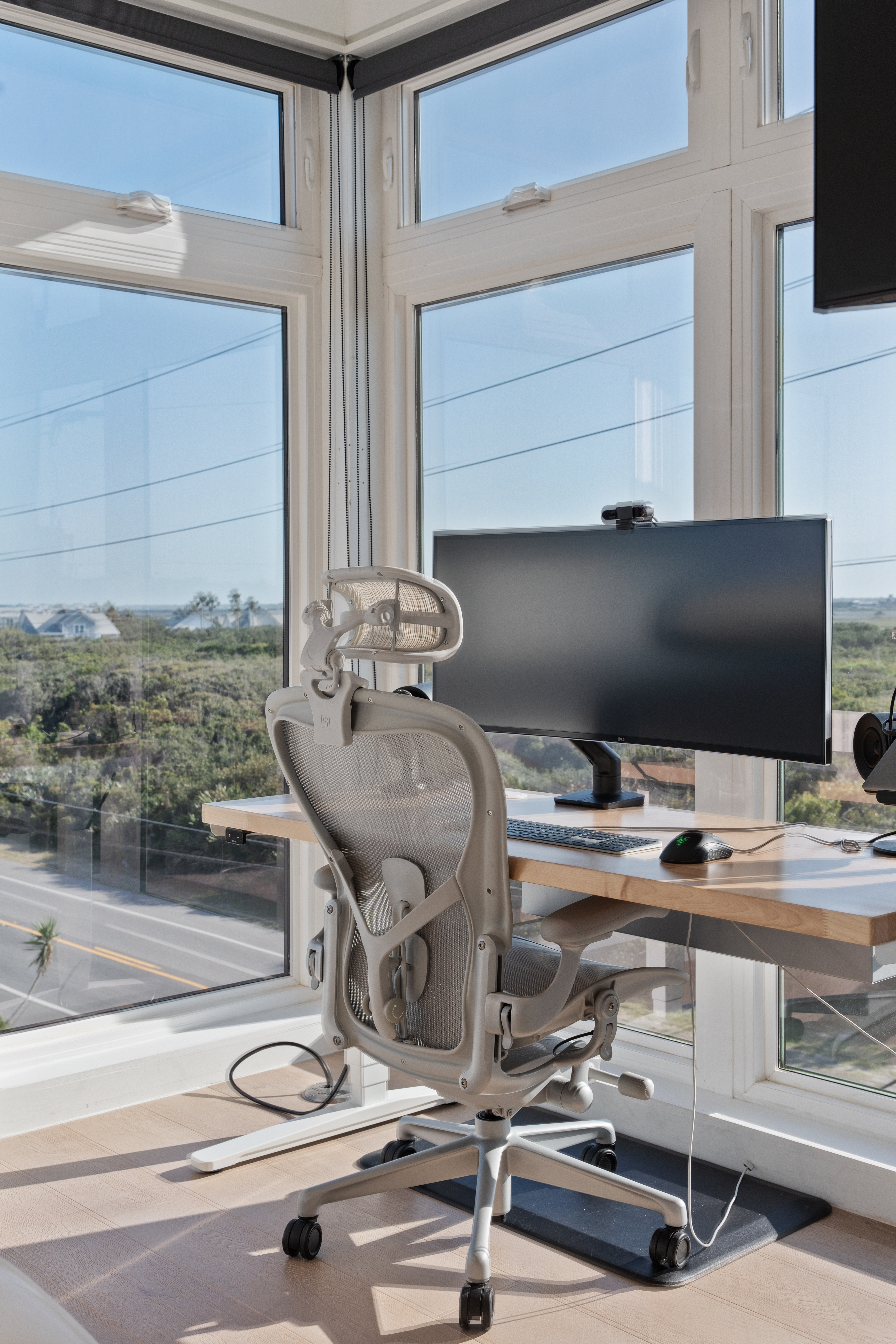 Sunny corner workspace with panoramic views and ergonomic desk setup