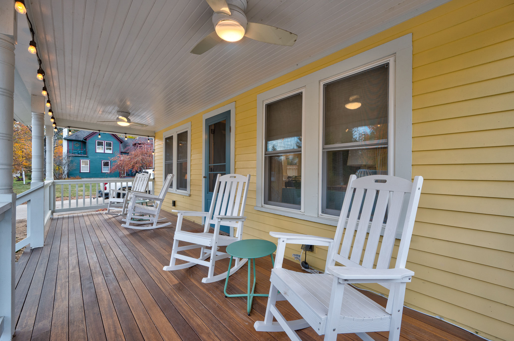 Charming covered porch with rocking chairs, fans, and cozy string lights