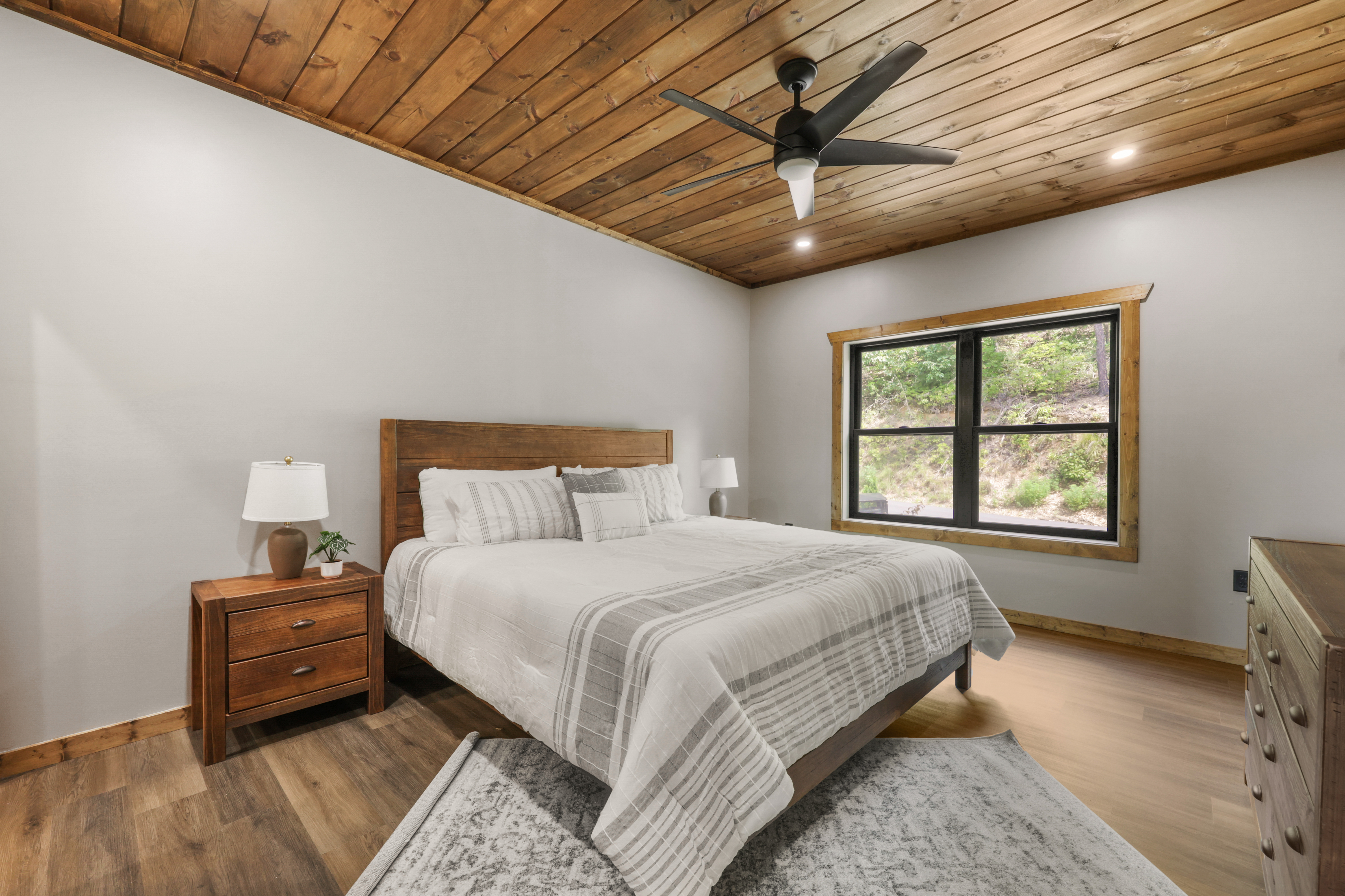 Cozy rustic-modern bedroom with wooded views and warm wood details