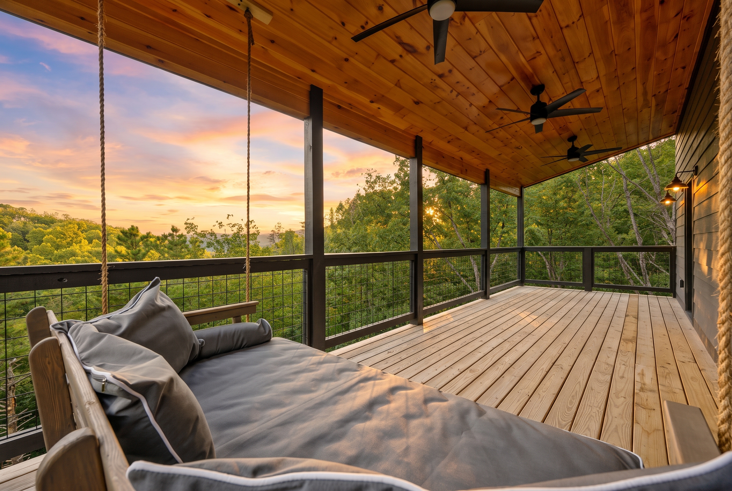 Sunset-view covered deck with hanging daybed and serene woodland views