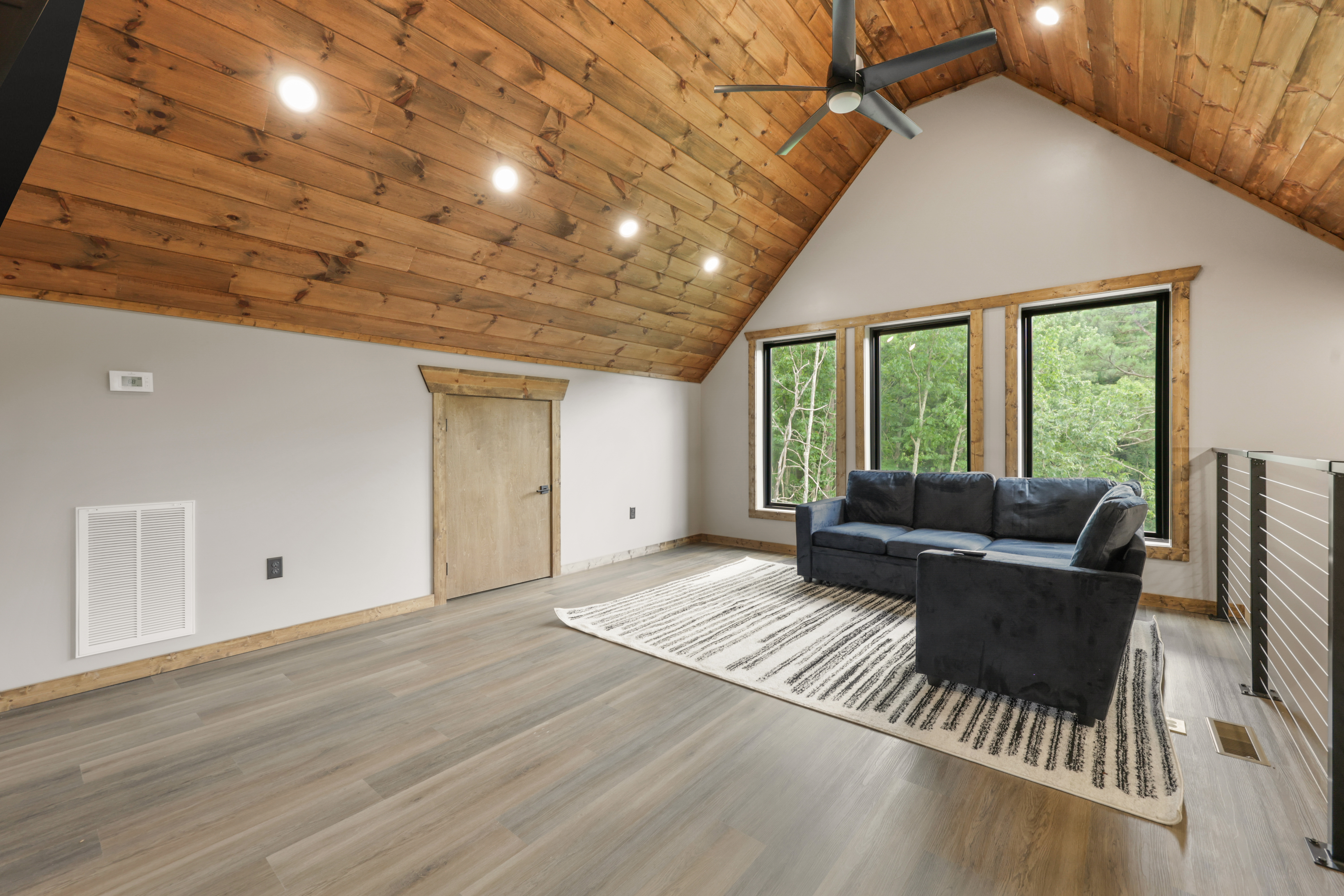 Cozy loft lounge with vaulted wood ceilings and serene forest views