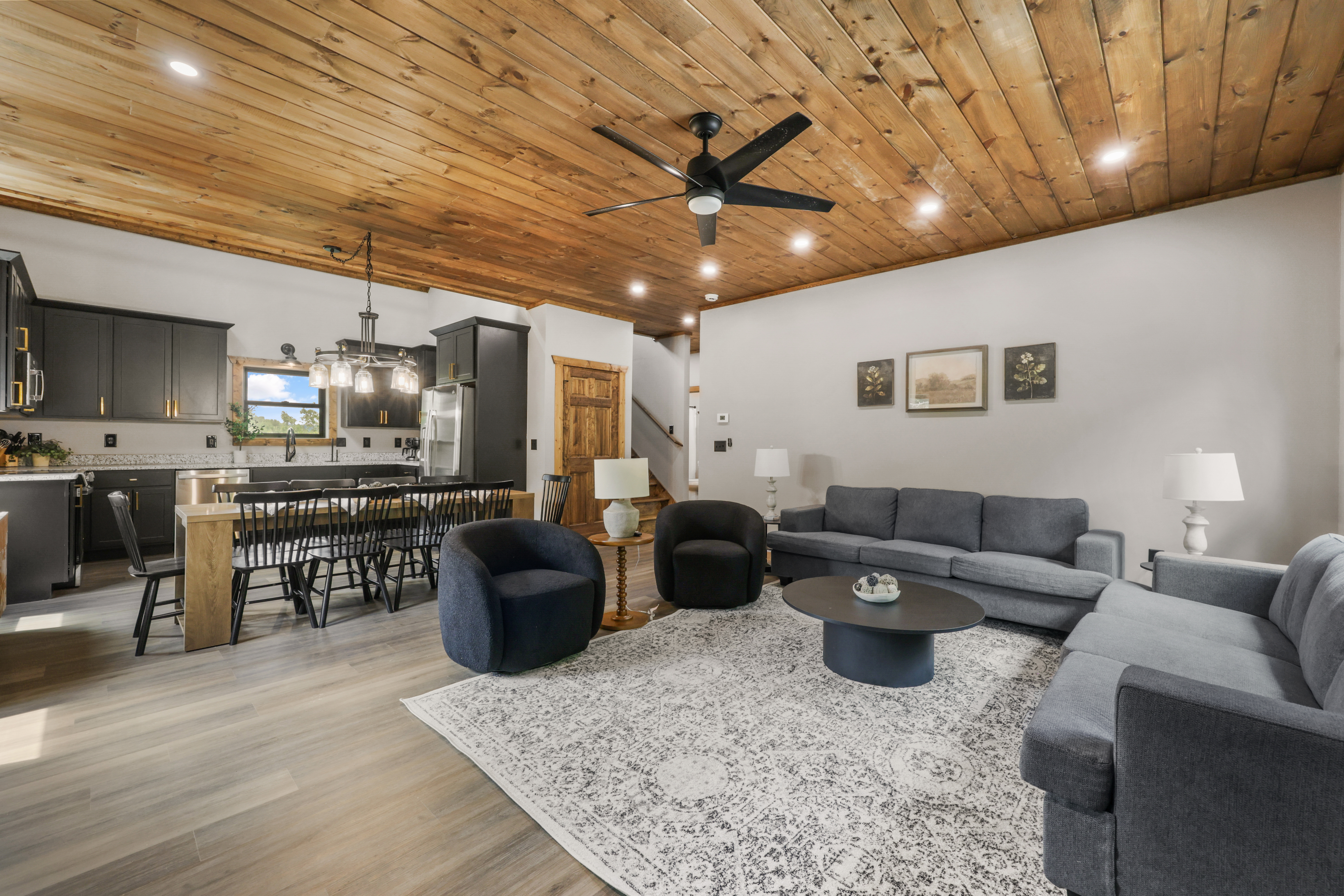 Spacious open living area with rustic wood ceiling and stylish seating