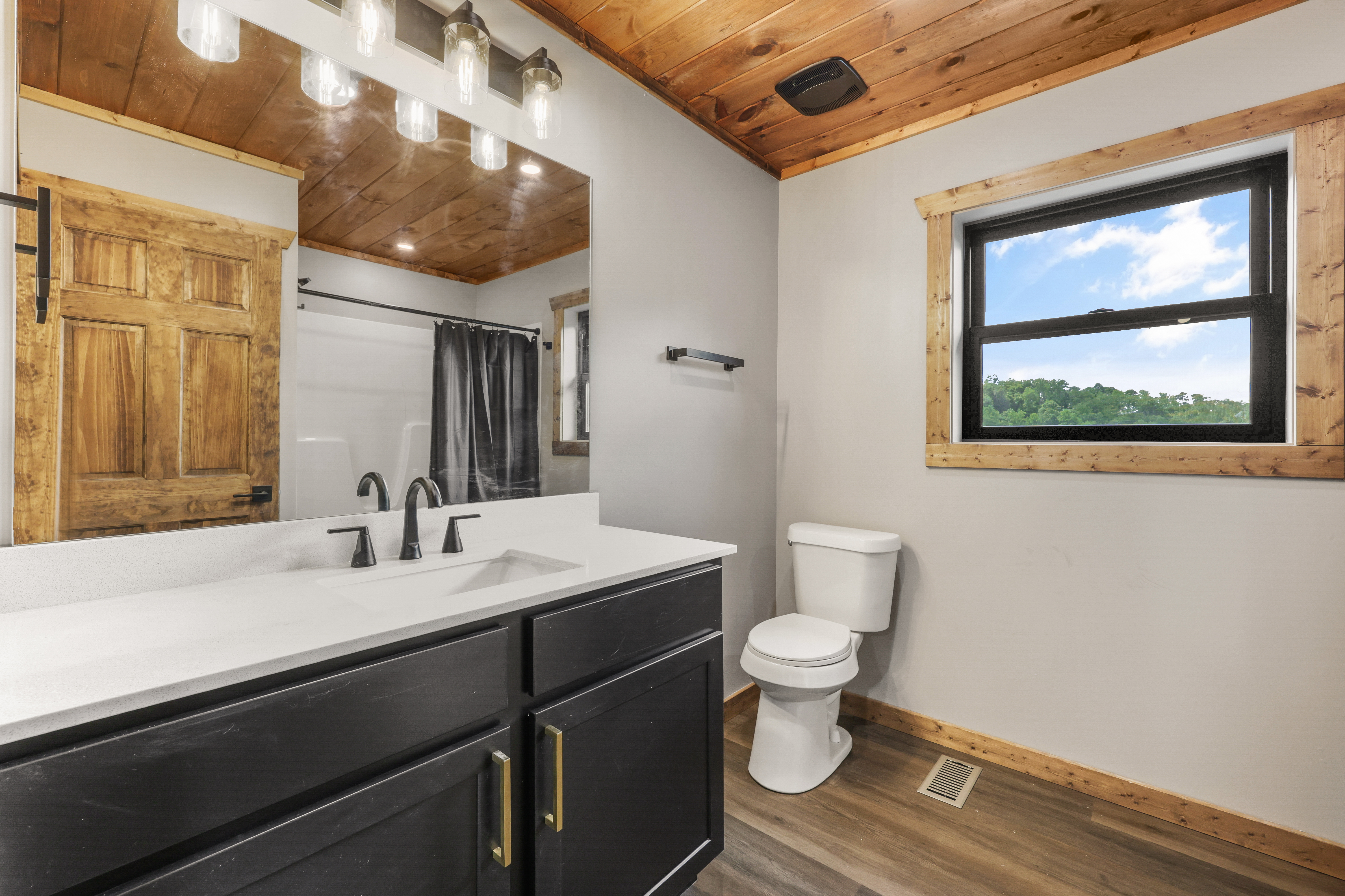 Bright rustic-modern bathroom with double vanity and scenic window views