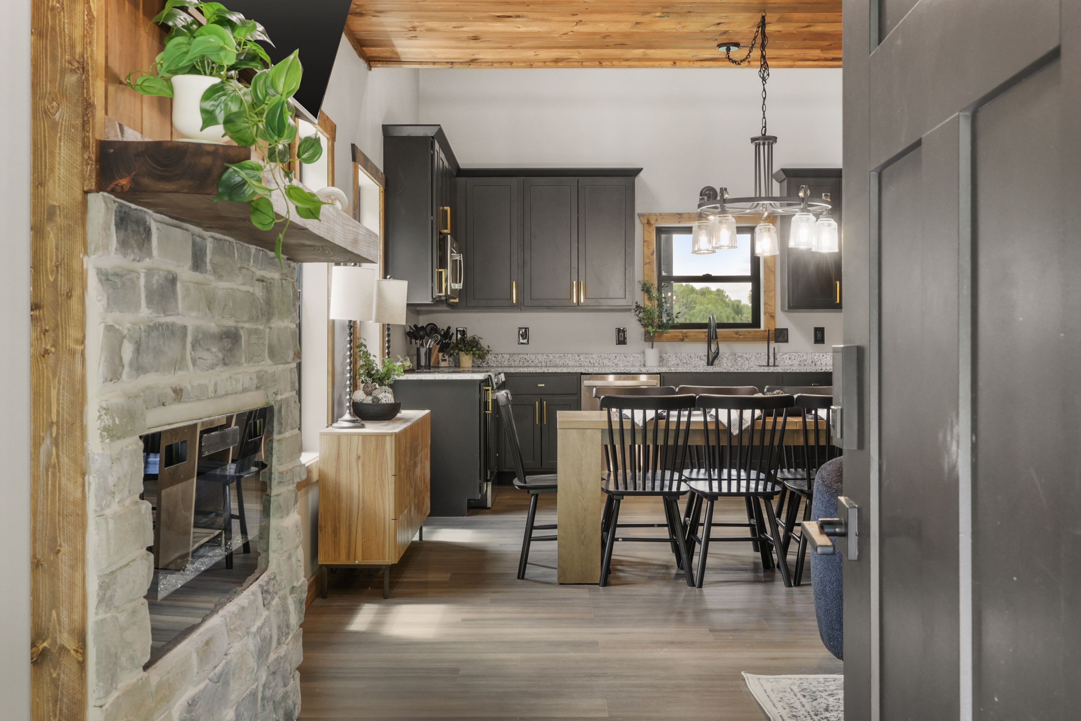 Modern rustic kitchen with stone fireplace and inviting dining space