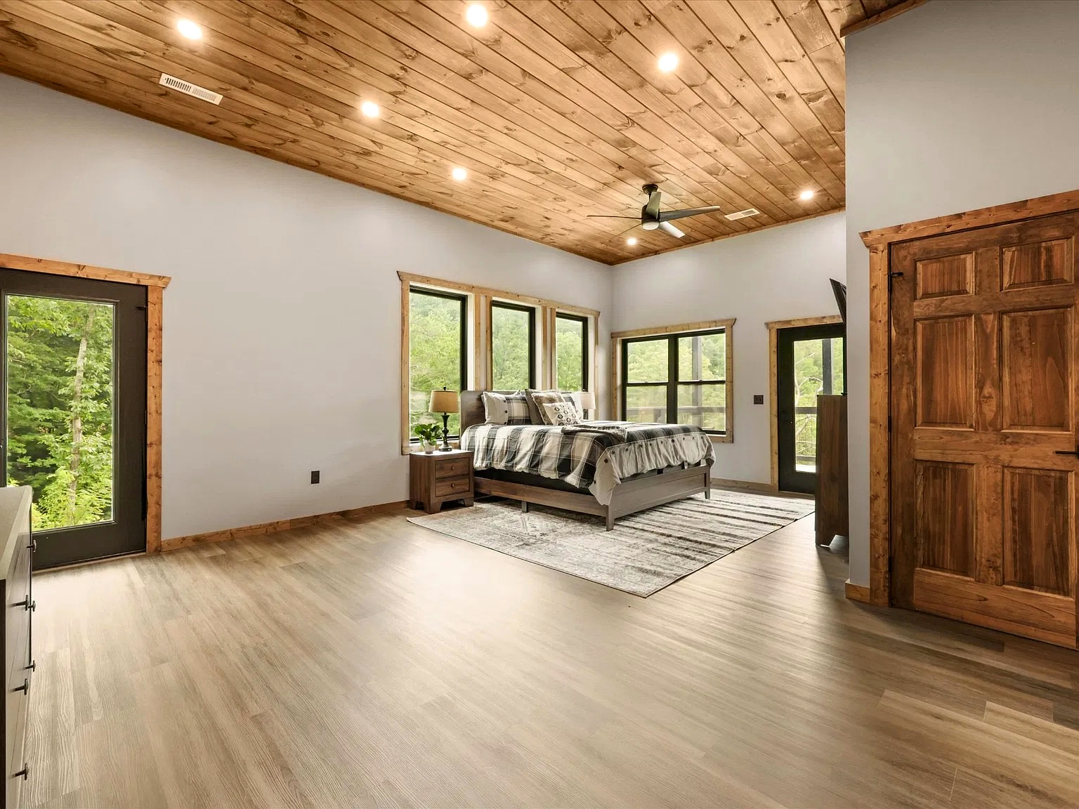 Spacious woodland bedroom with soaring wood ceilings and serene views