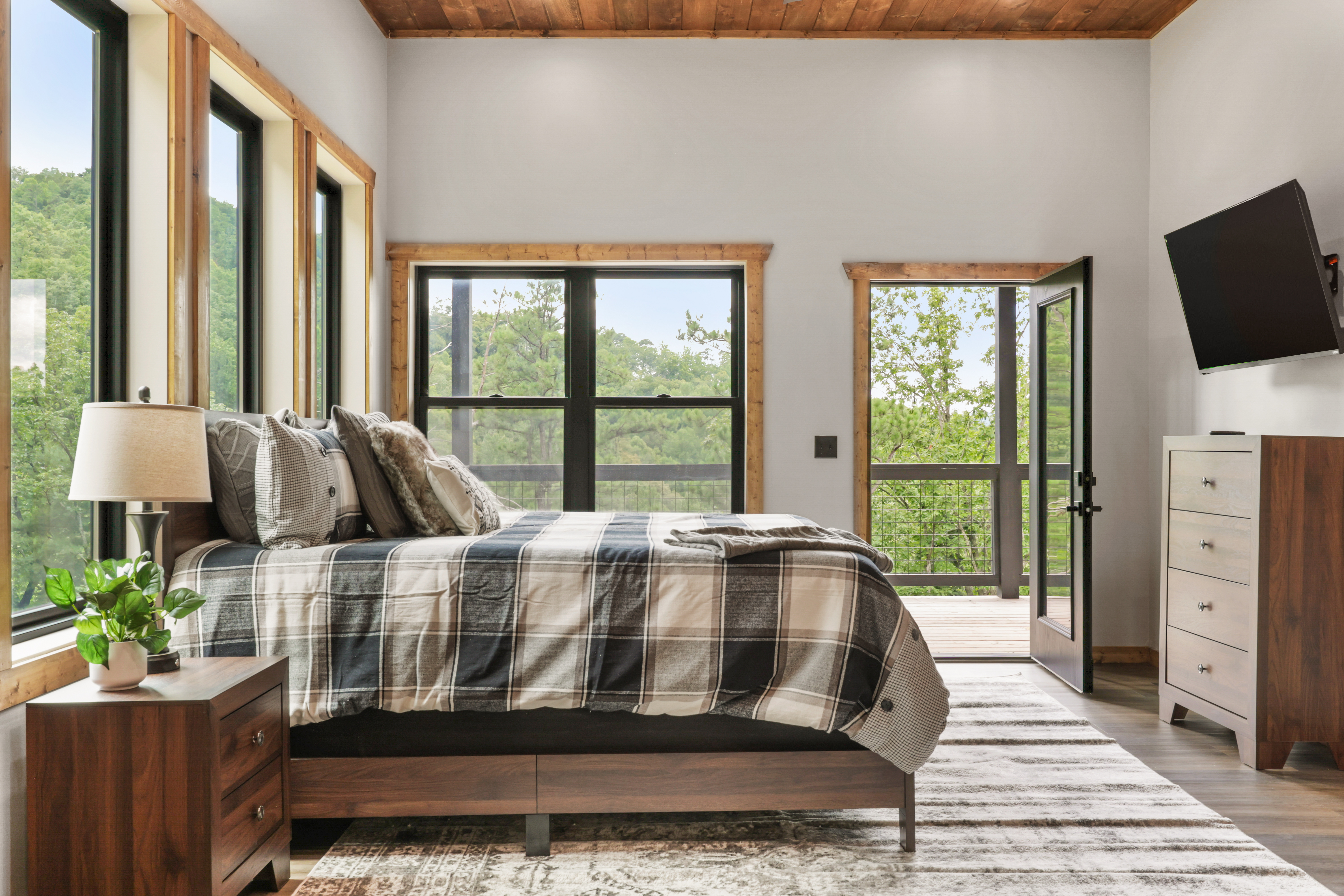 Bright modern bedroom with wooded views and private balcony access