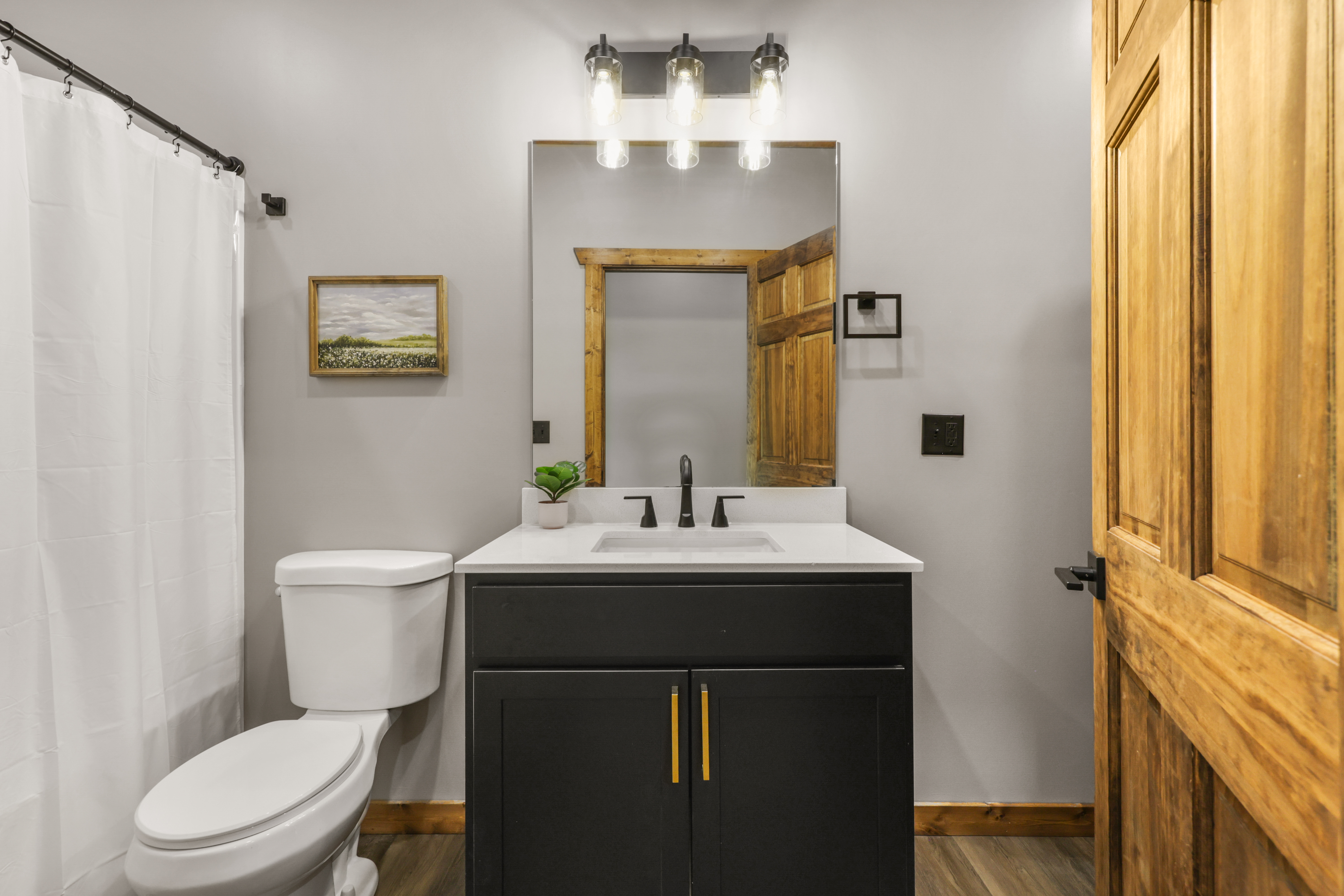 Modern rustic bathroom with stylish lighting and warm wood accents