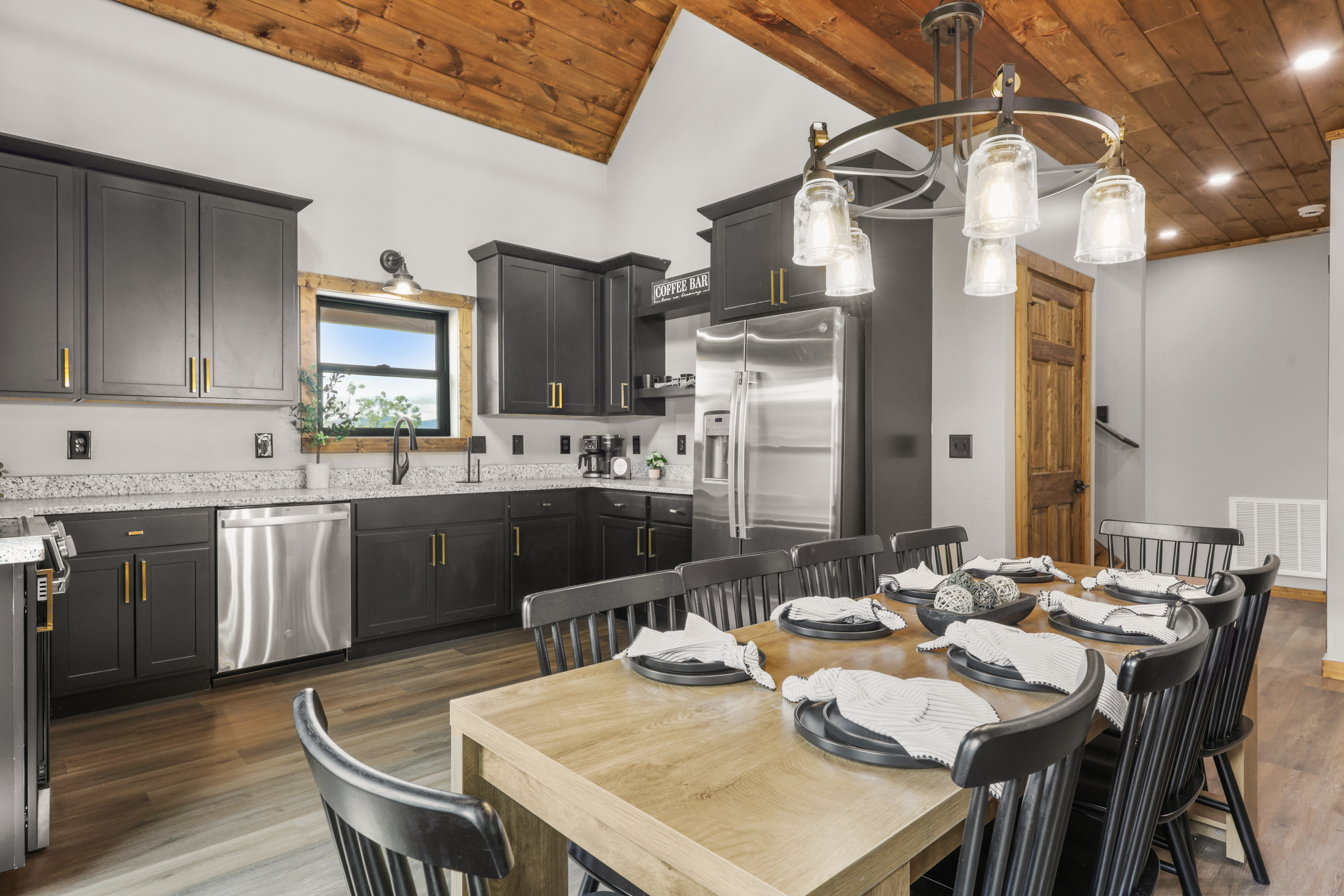Rustic-modern kitchen with vaulted wood ceilings and dining for 8