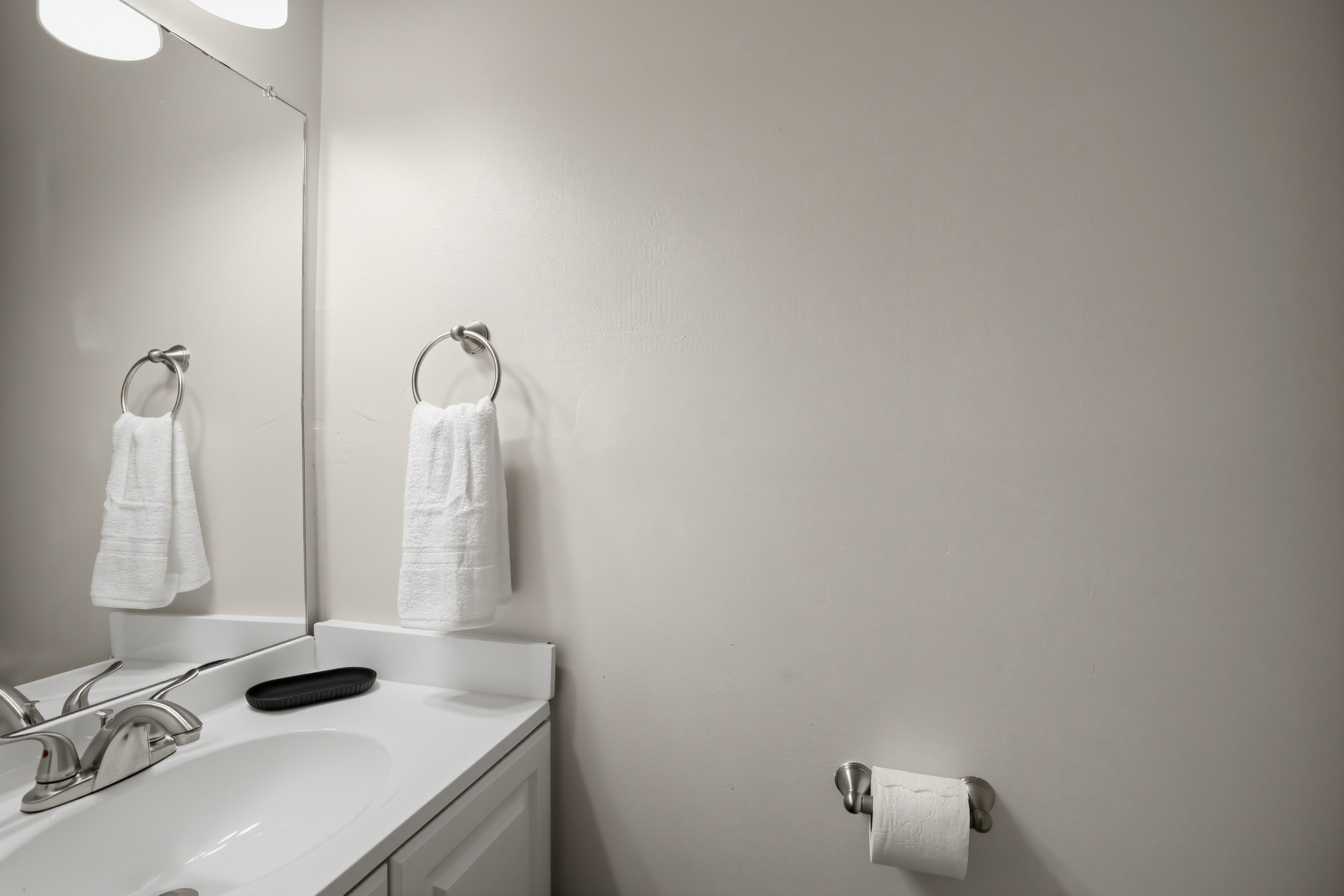 Bright, clean bathroom vanity with fresh towels and a large mirror