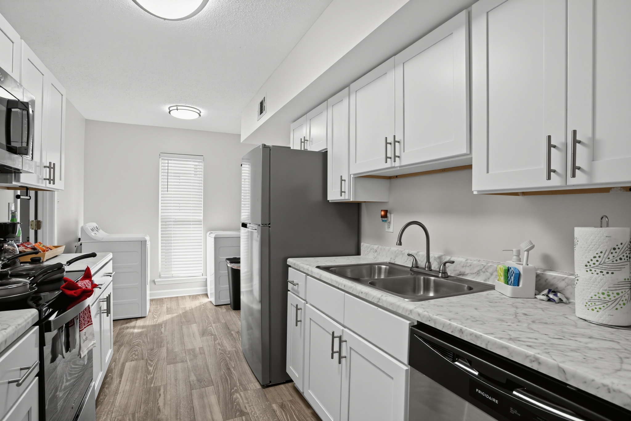 Bright modern kitchen with stainless appliances and in-unit laundry