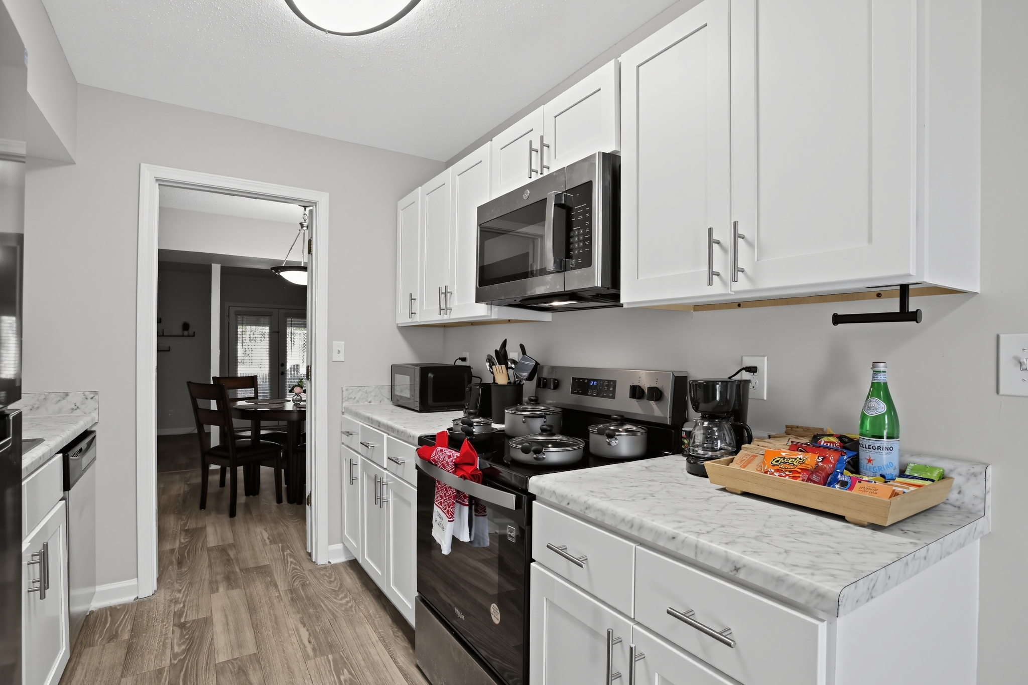 Bright modern kitchen with stainless appliances and stocked coffee station
