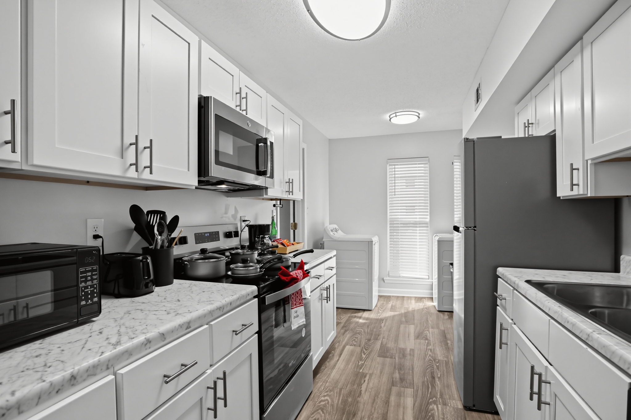 Bright modern kitchen with marble-look counters and in-unit laundry