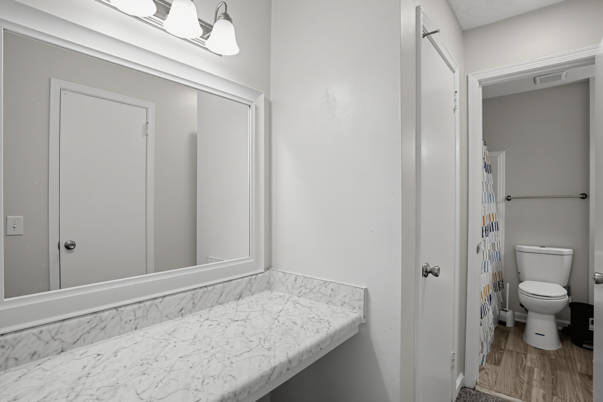 Bright vanity with large mirror and spacious marble-look countertop