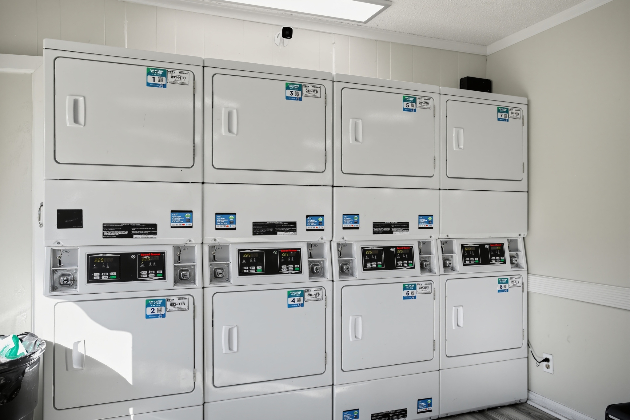 Bright on-site laundry room with multiple washers and dryers