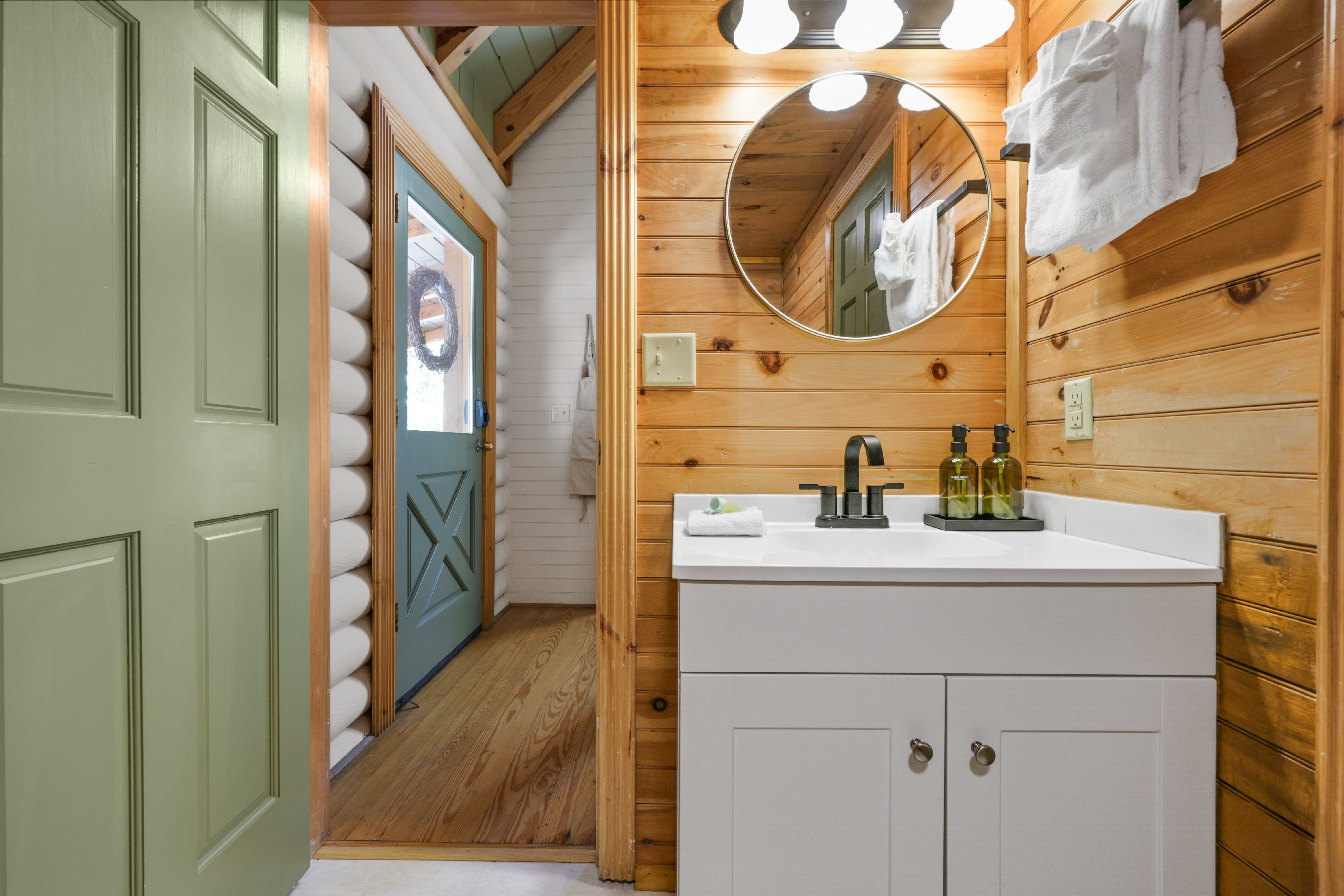 Cozy cabin bathroom with modern vanity, warm wood finishes, and bright lighting