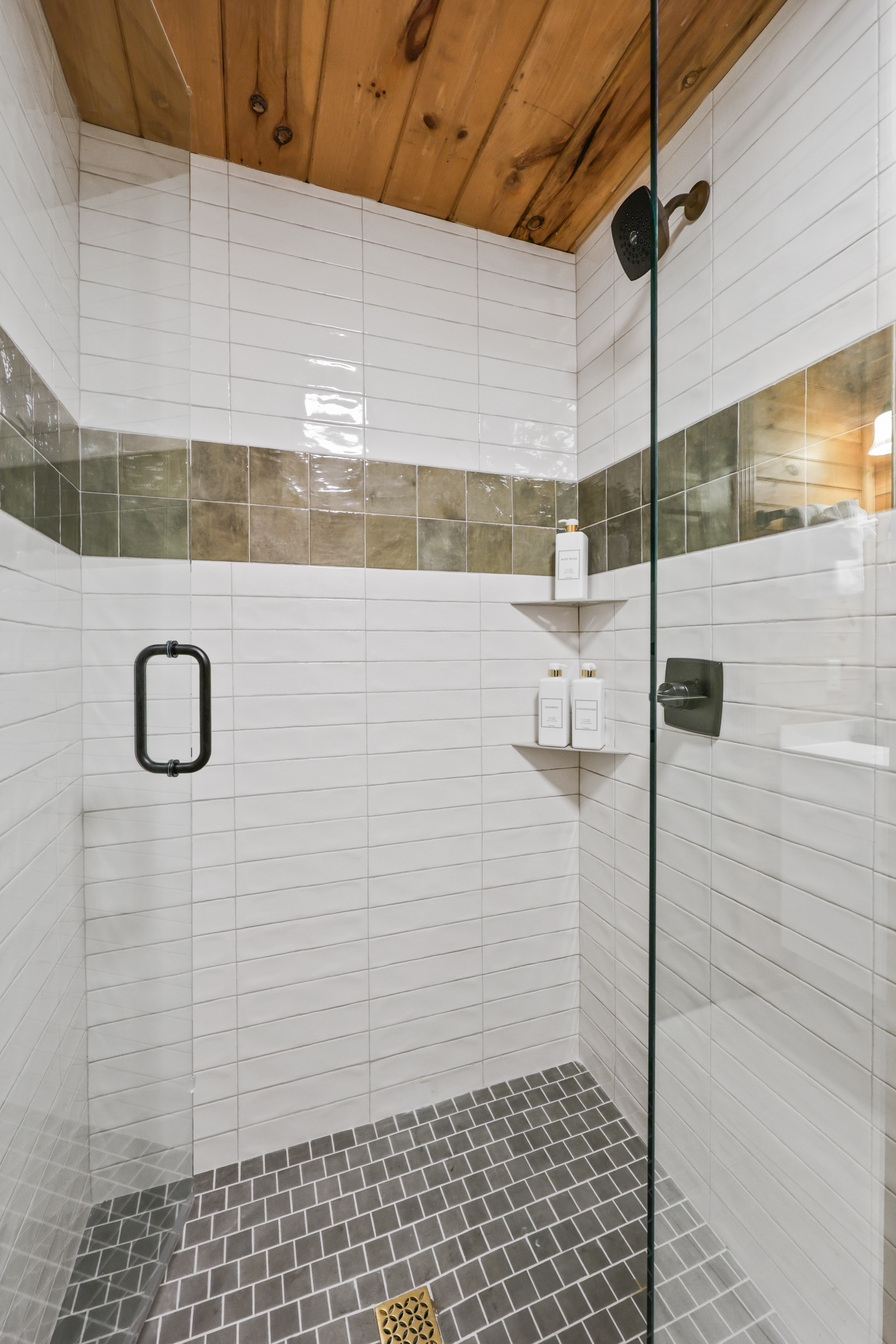 Spa-like walk-in shower with glass enclosure and warm rustic details