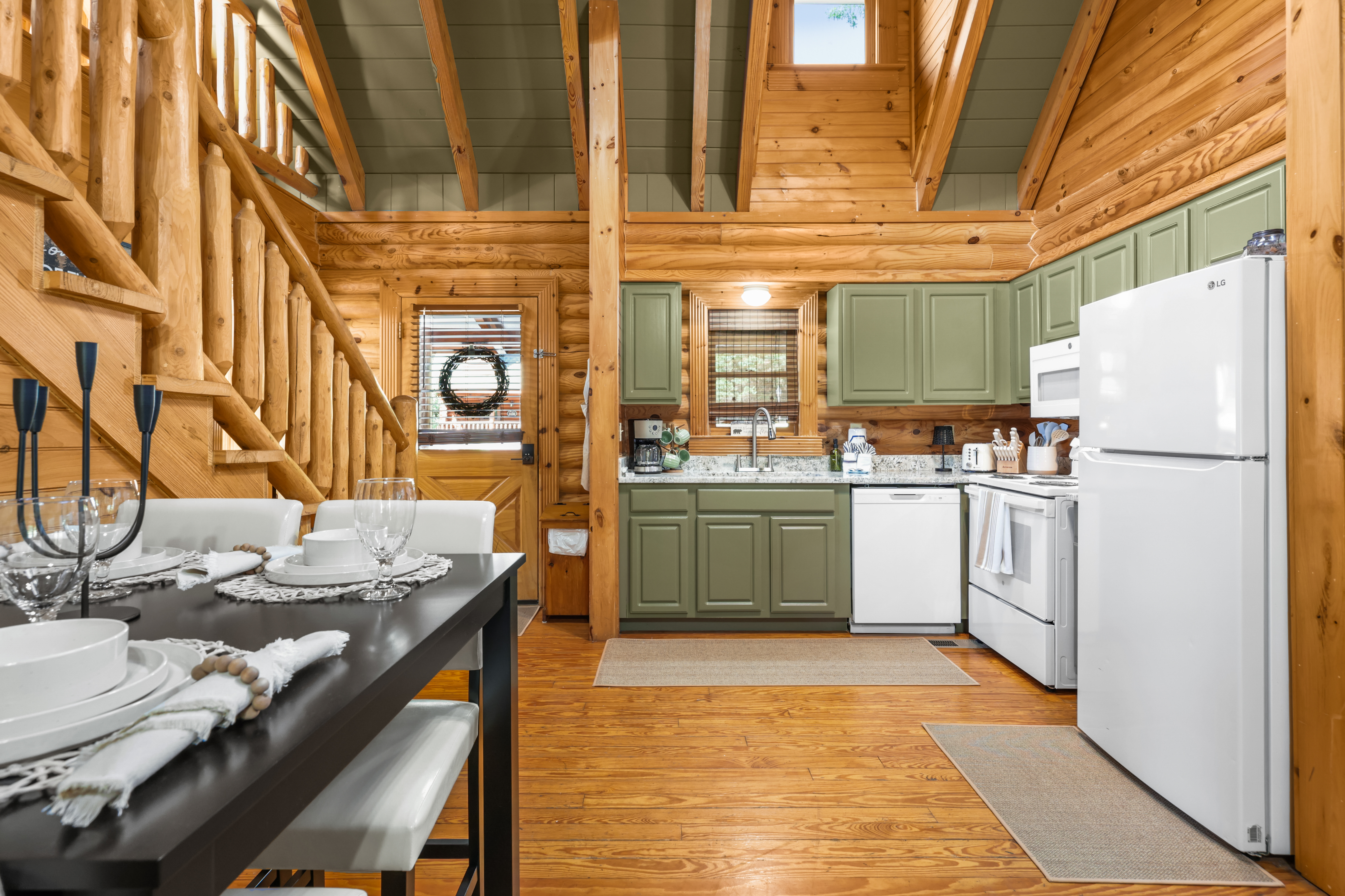 Cozy log cabin kitchen with rustic charm, lofted ceilings, and dining space