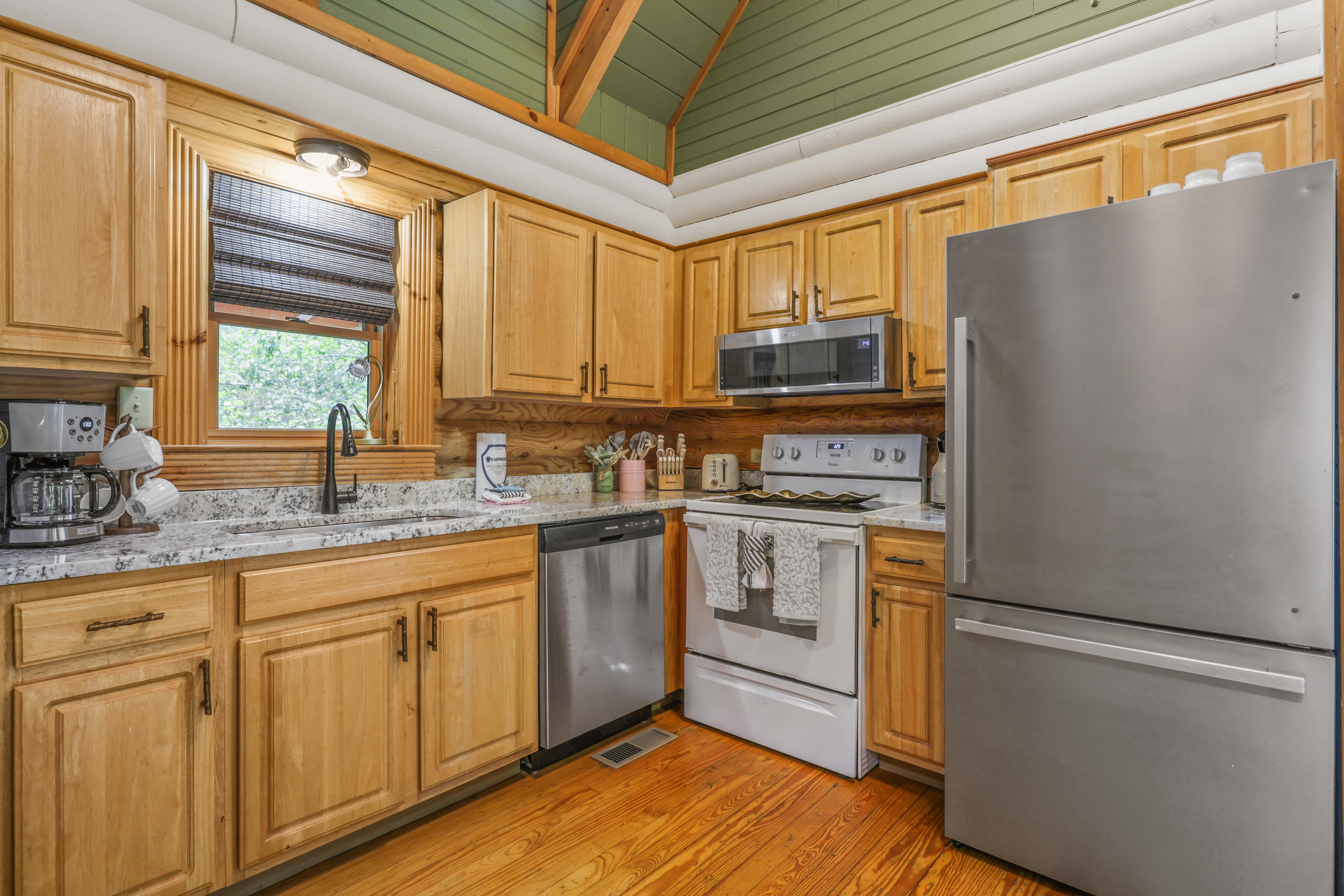 Cozy wood-accented kitchen with stainless appliances and vaulted ceiling
