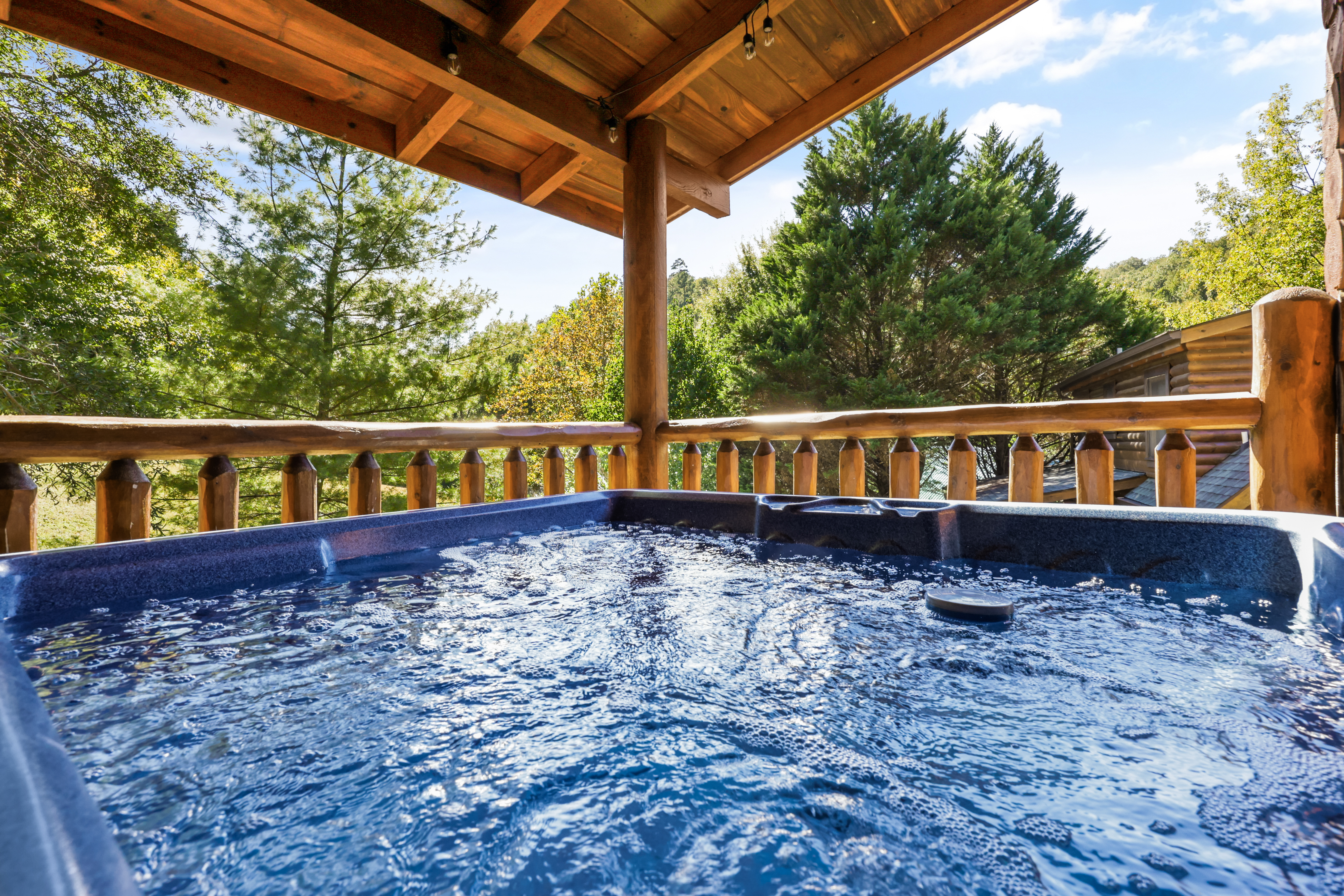 Private covered hot tub with serene wooded views and cozy cabin charm