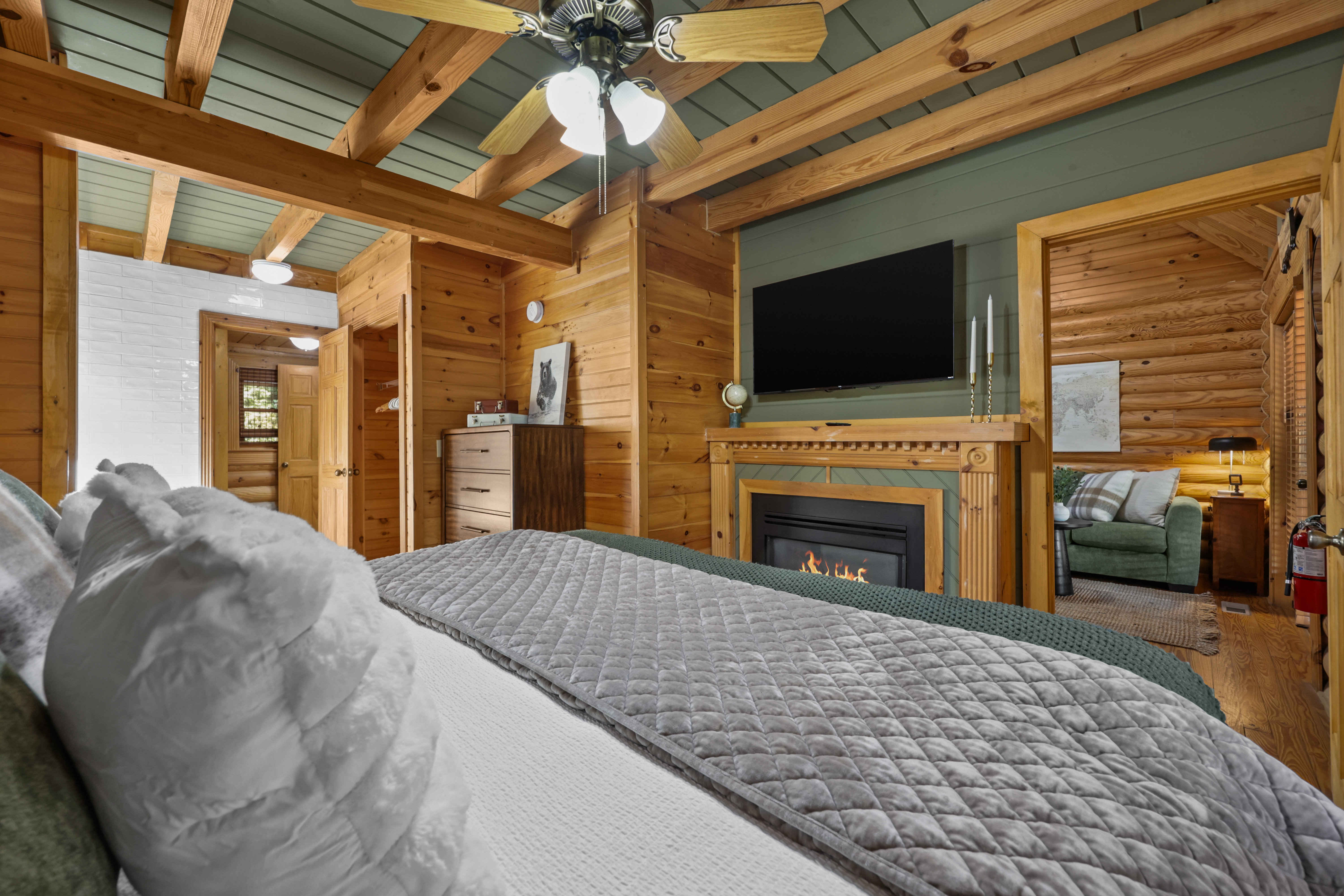 Cozy wood-beamed bedroom with fireplace, TV, and adjoining lounge