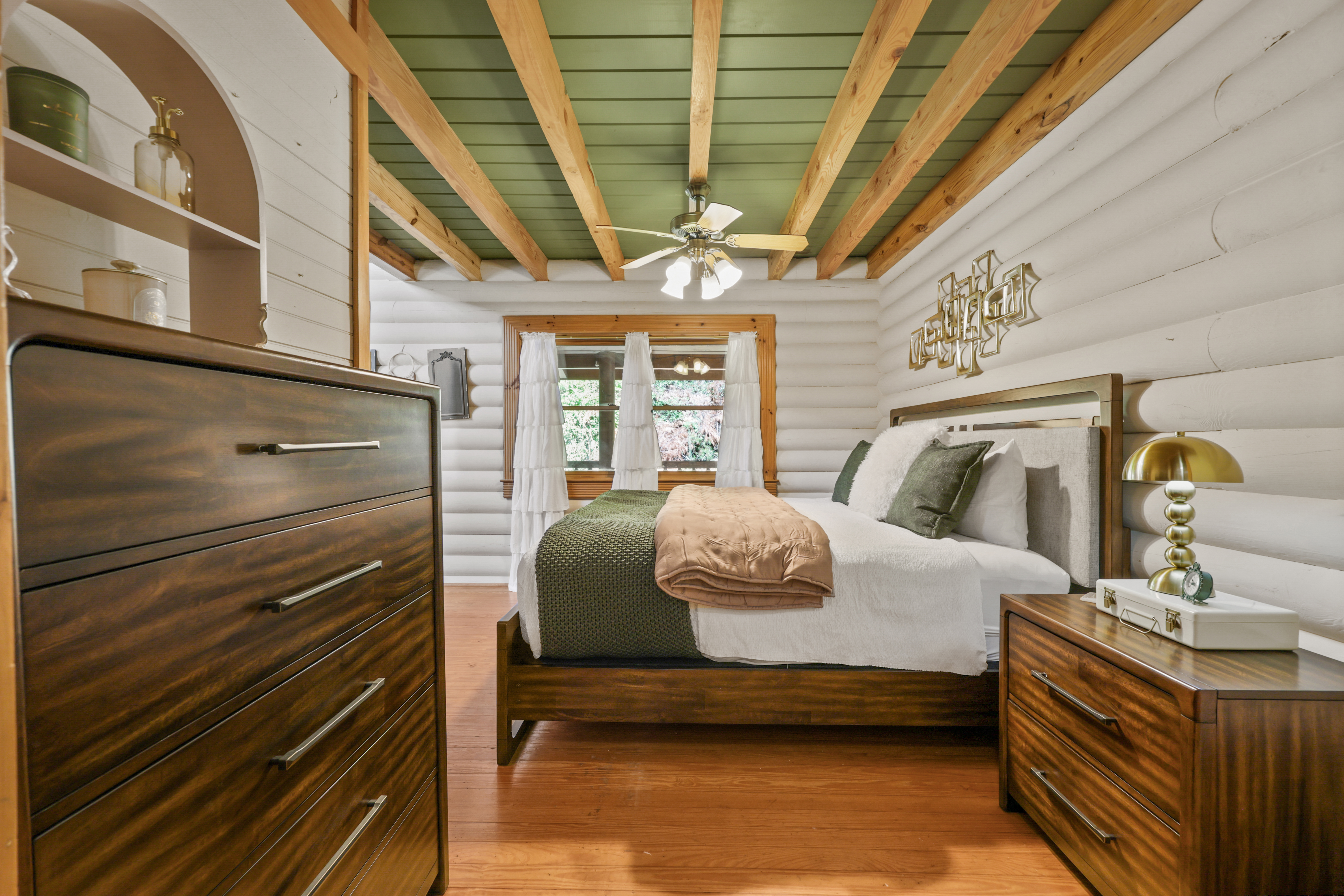 Cozy rustic bedroom with wood beams, warm finishes, and inviting cabin charm