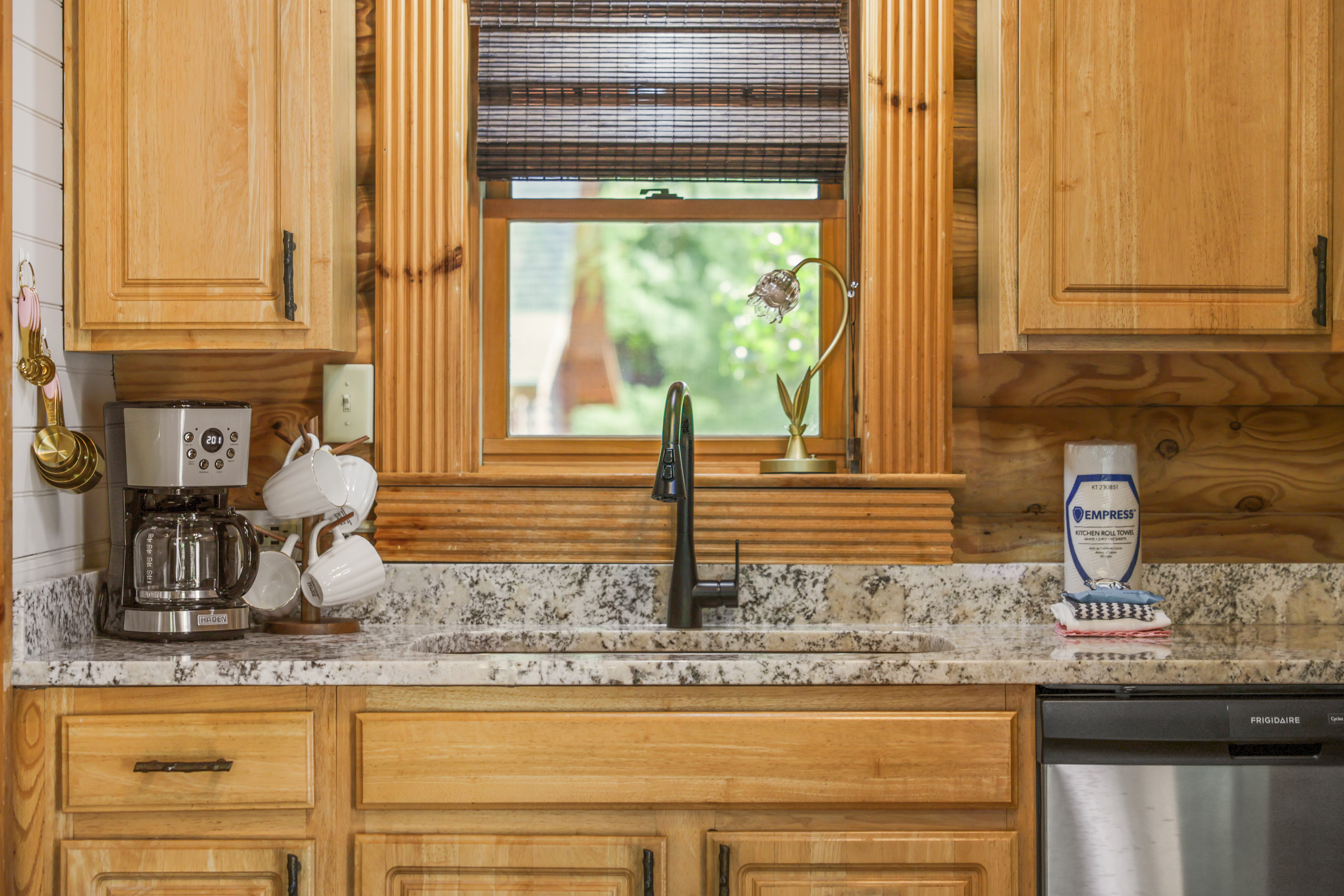 Cozy wood-accented kitchen with granite counters and a bright window view