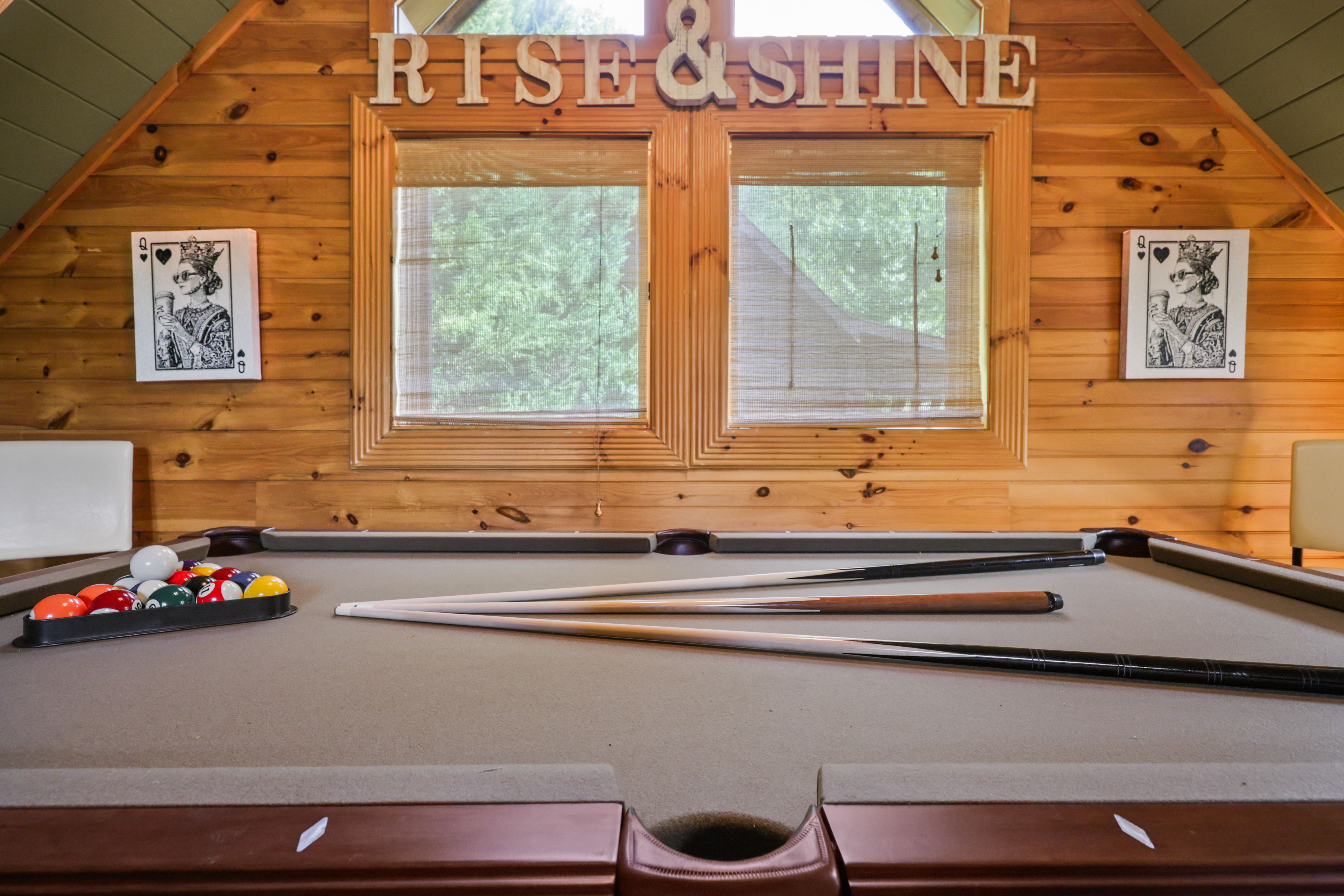 Cozy cabin game room with pool table and bright woodland views