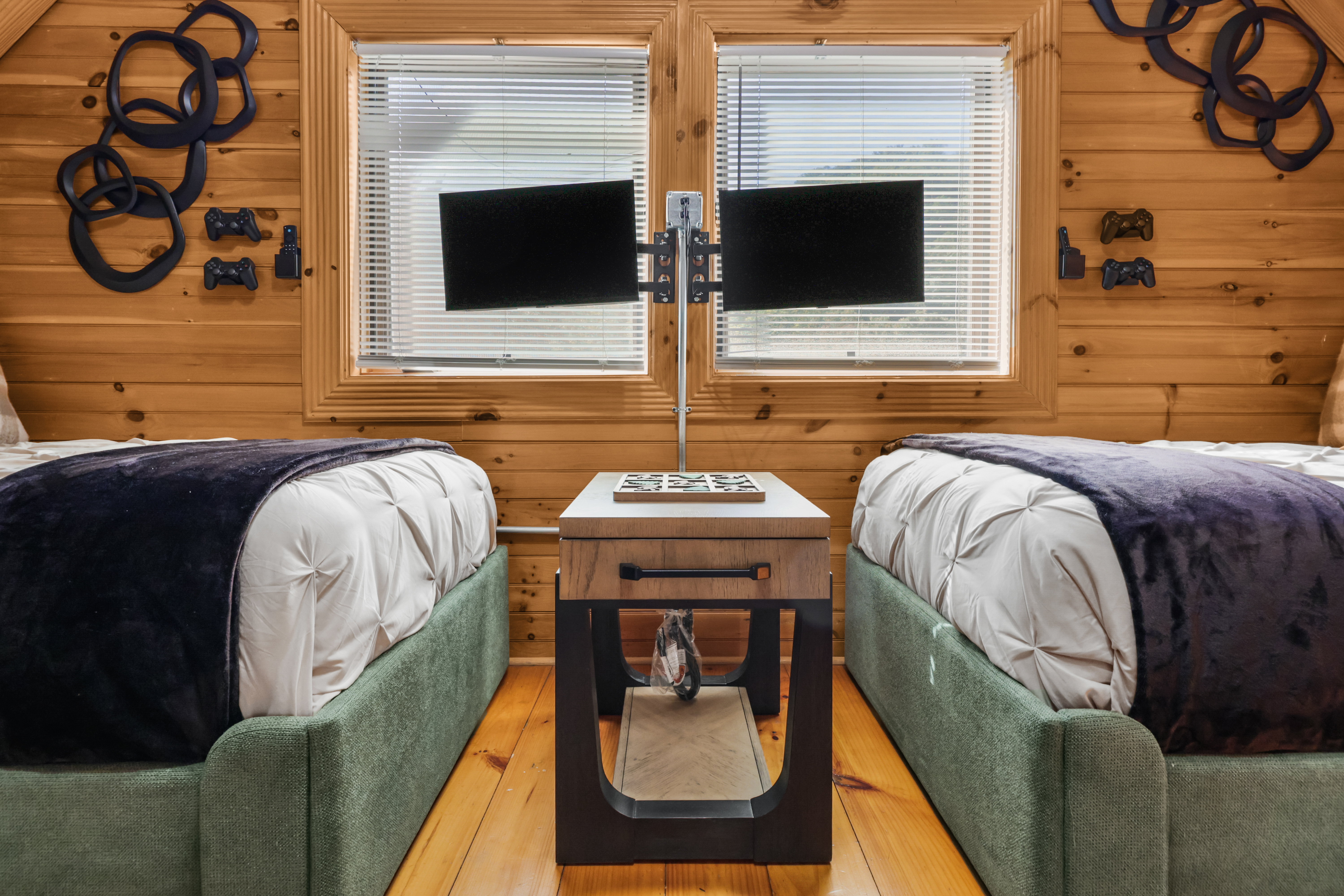 Cozy twin bedroom with rustic charm, dual TVs, and fun gaming decor