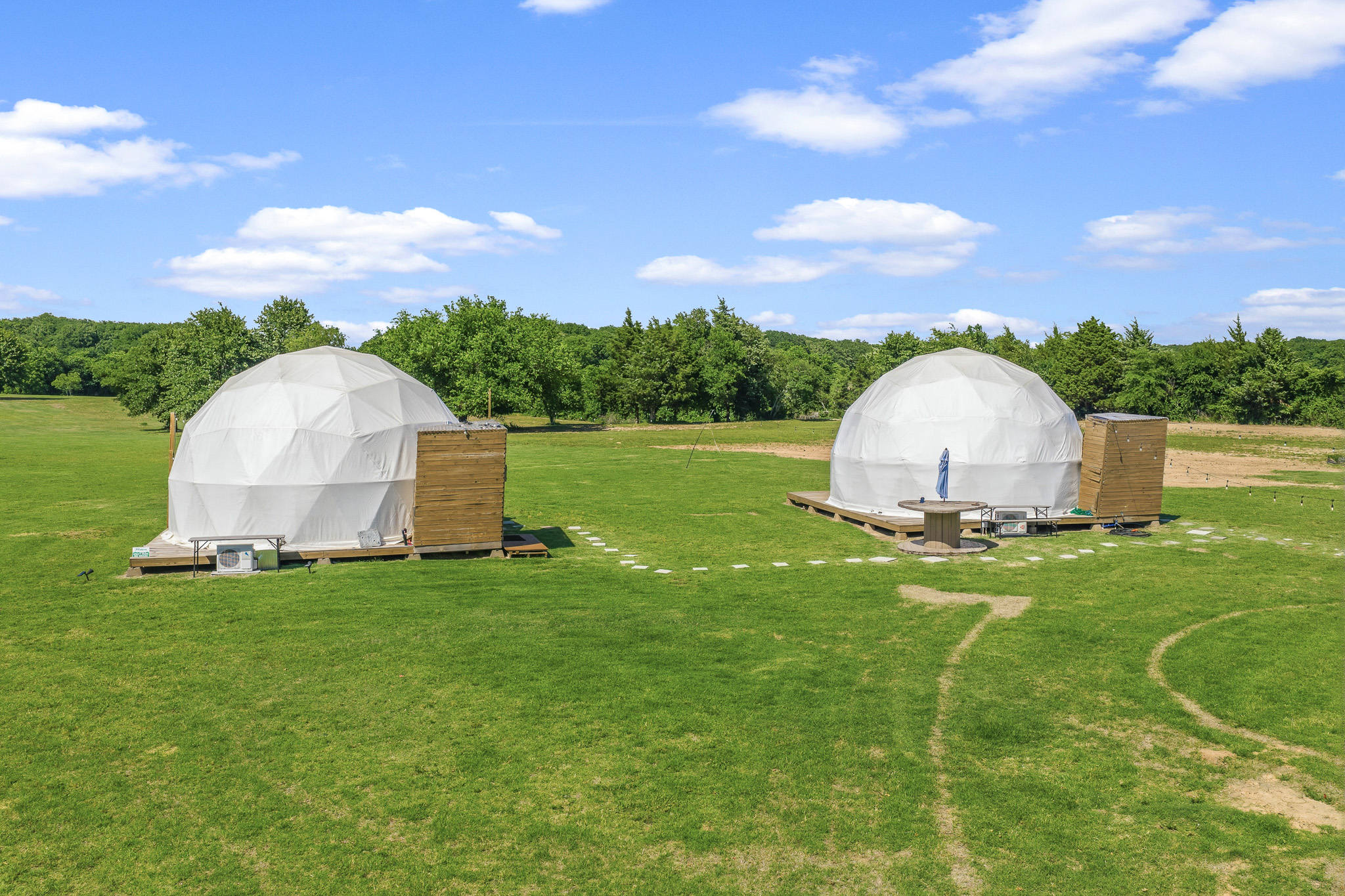 Scenic glamping domes with open lawns and peaceful countryside views