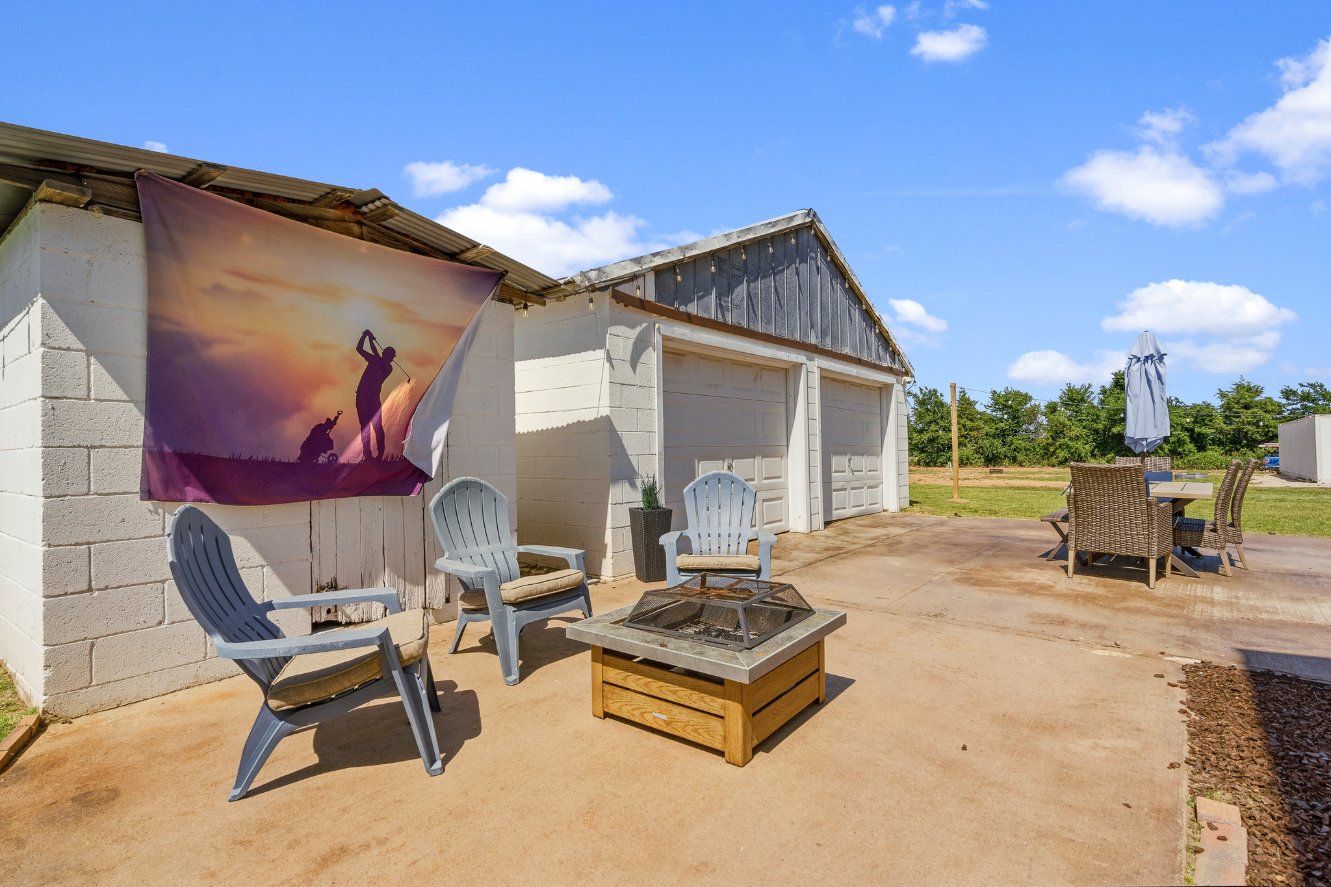 Spacious patio with fire pit, dining area, and open country views