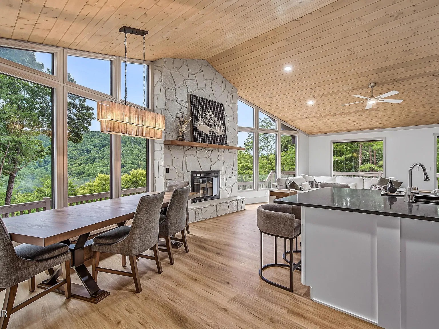 Vaulted great room with stone fireplace and panoramic mountain views