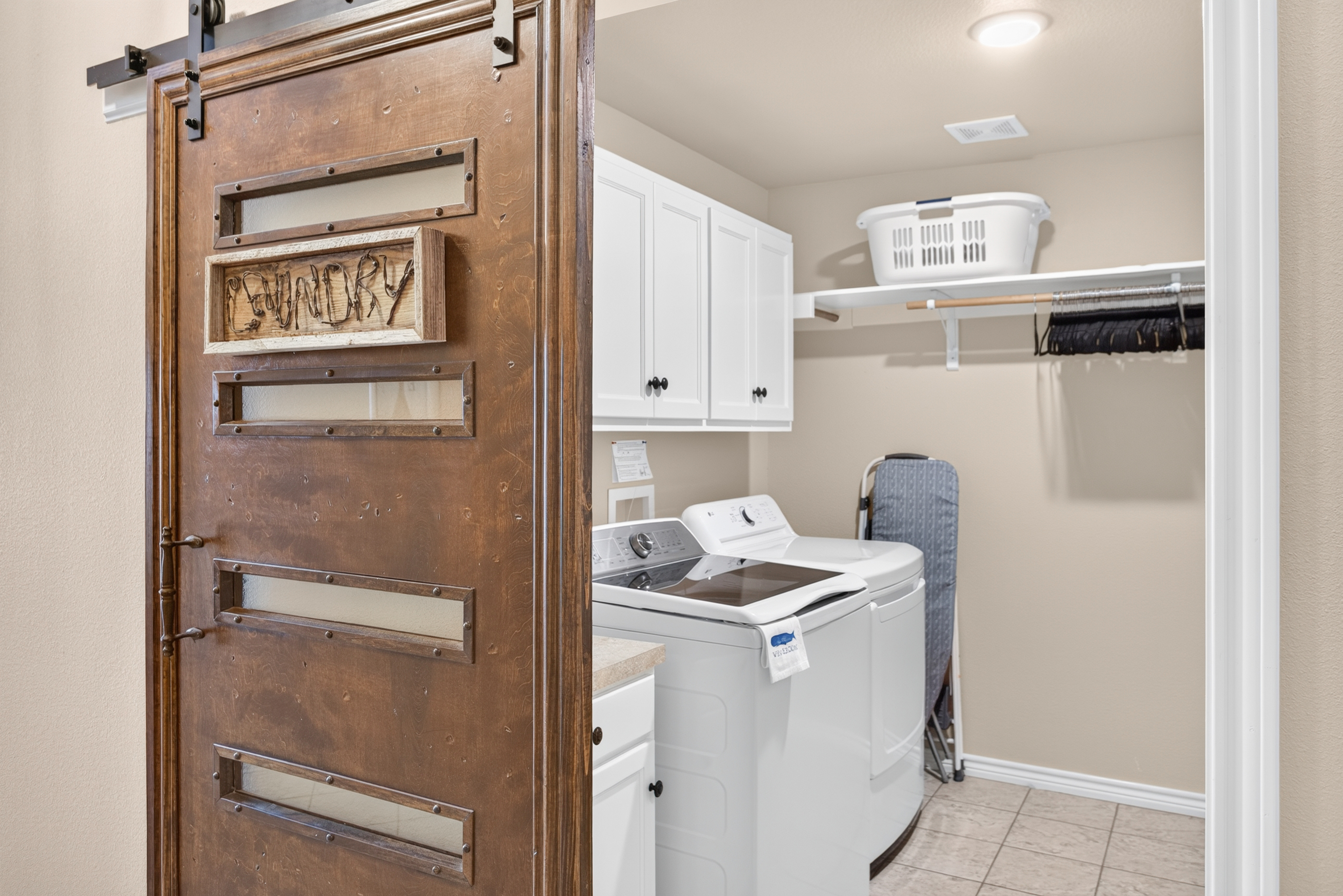 Dedicated laundry room with full-size washer/dryer and rustic barn door