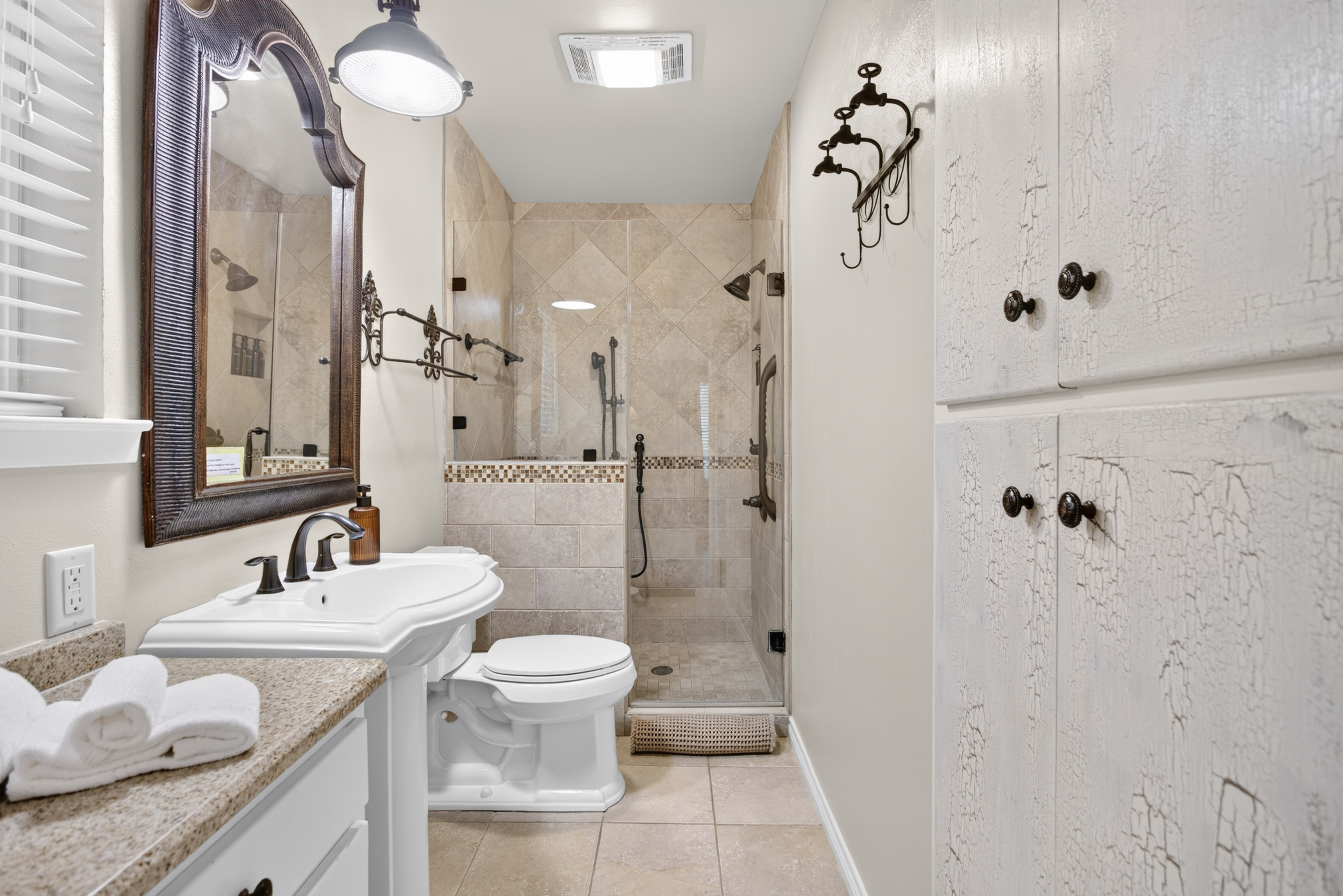 Bright spa-like bath with tiled walk-in shower and granite vanity
