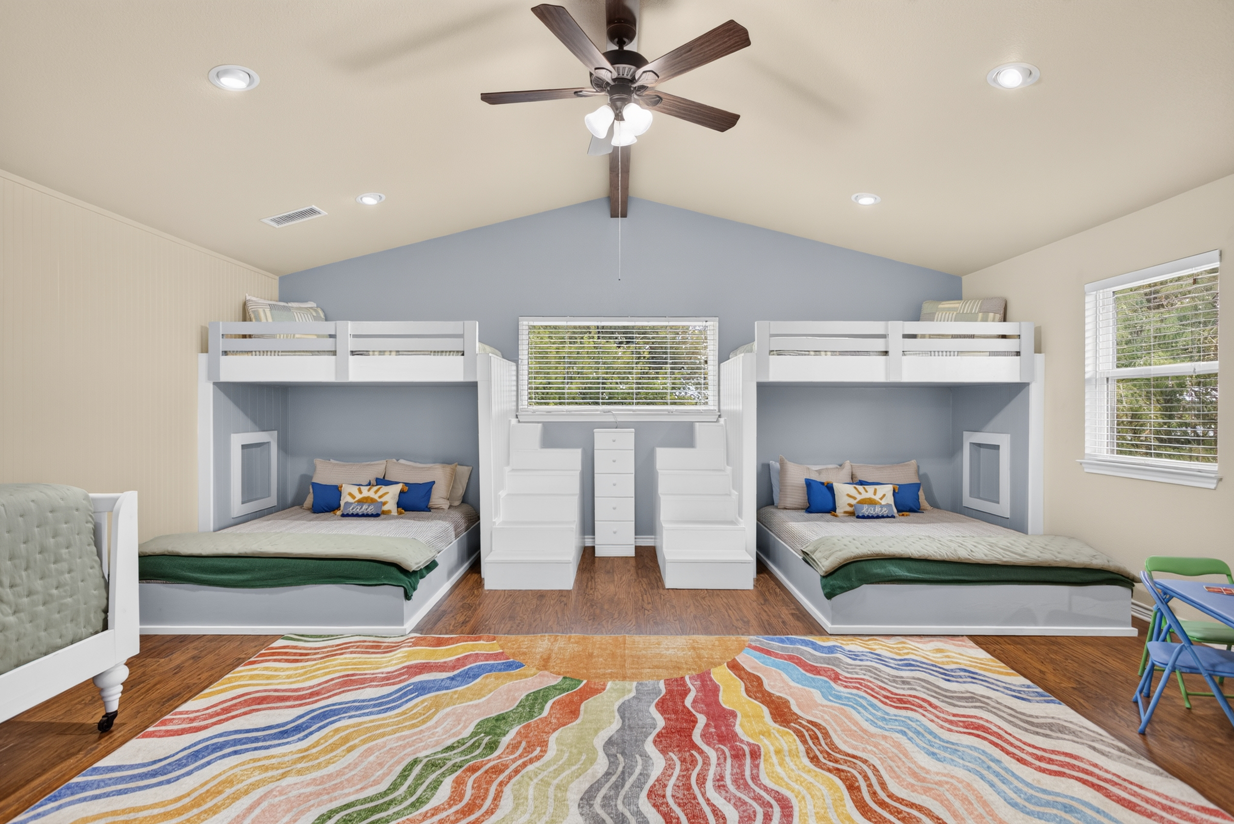 Spacious bunk room with built-ins, vaulted ceiling, and playful style