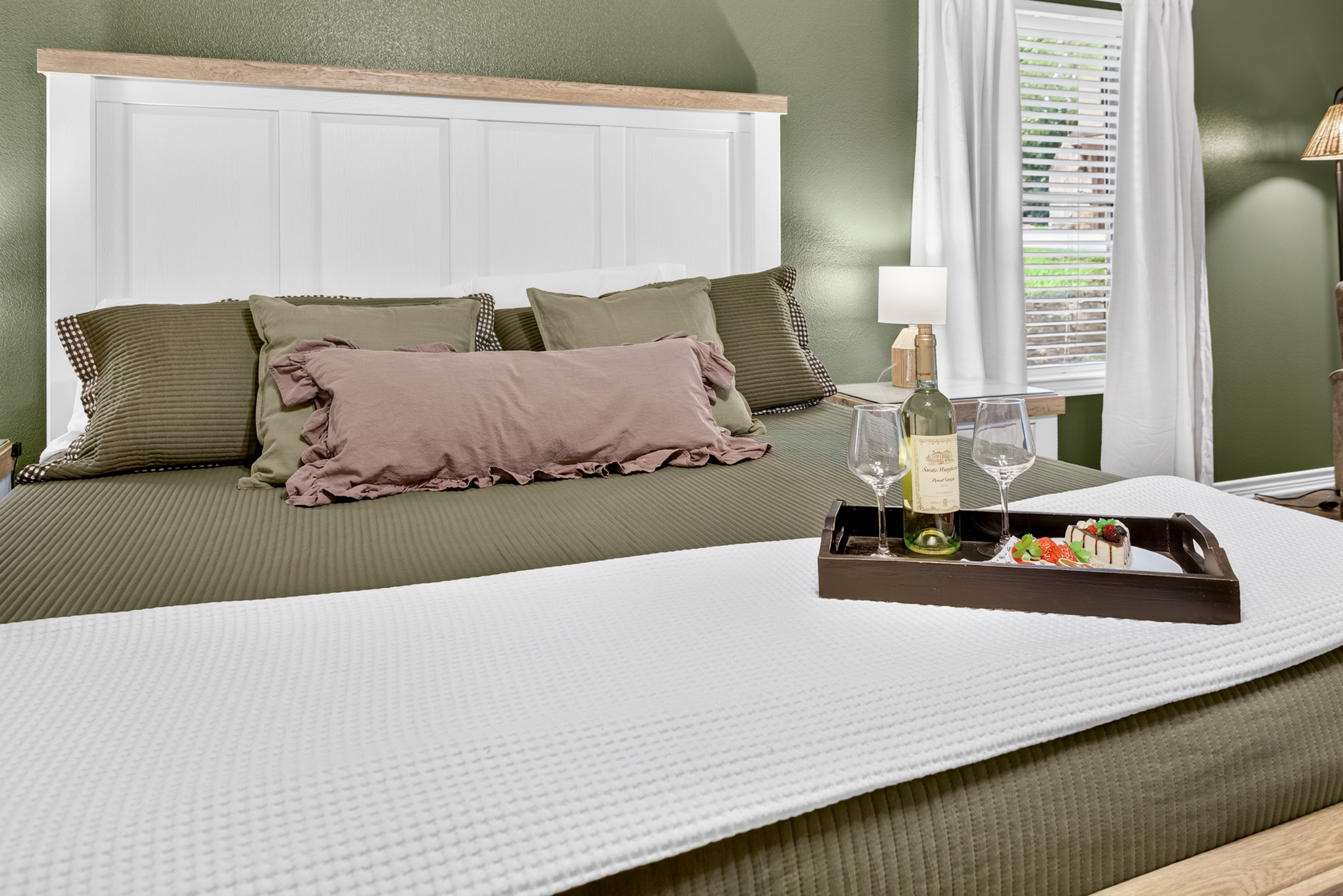 Cozy, stylish bedroom with natural light and a romantic welcome tray