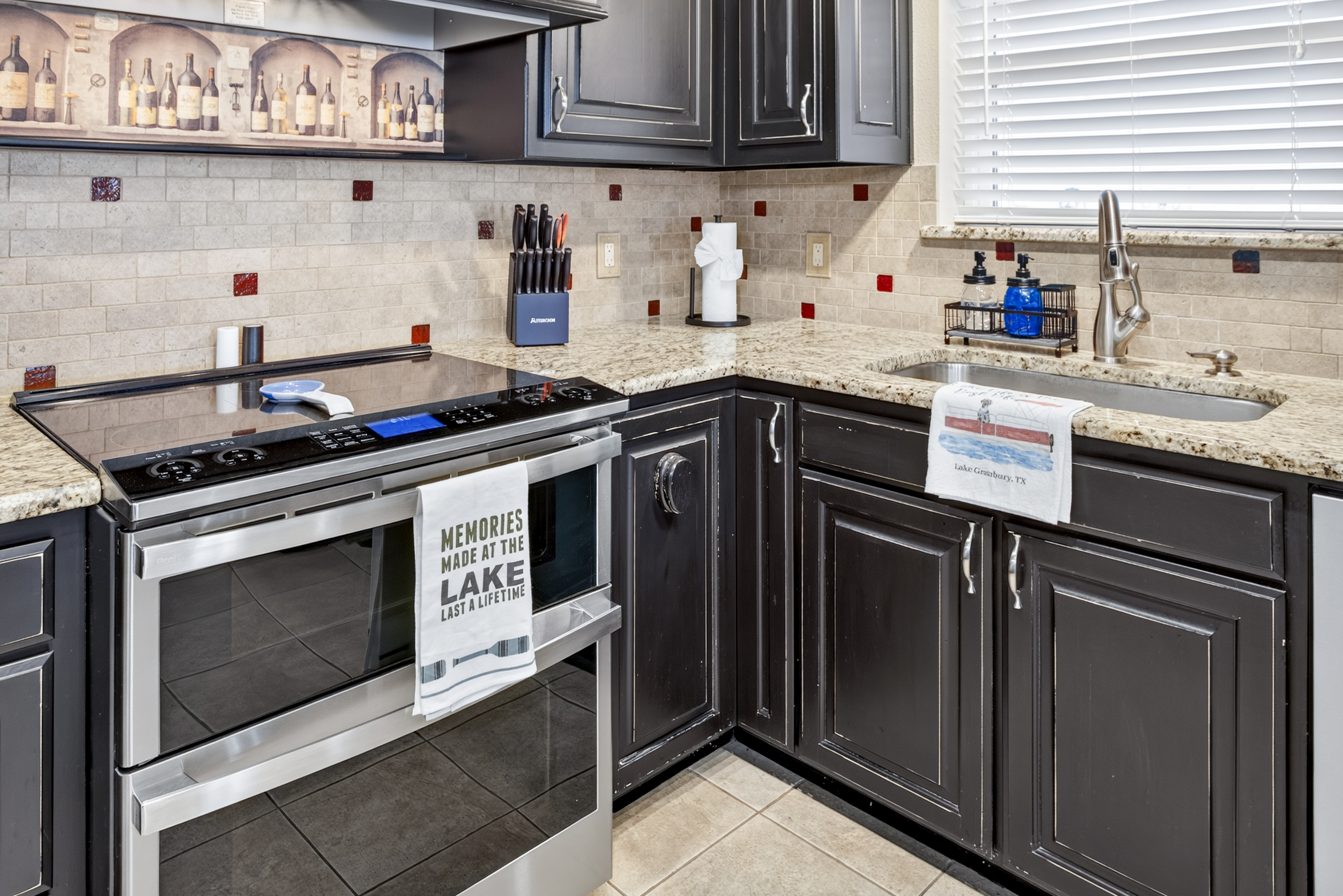 Stylish granite kitchen with stainless appliances and bright window