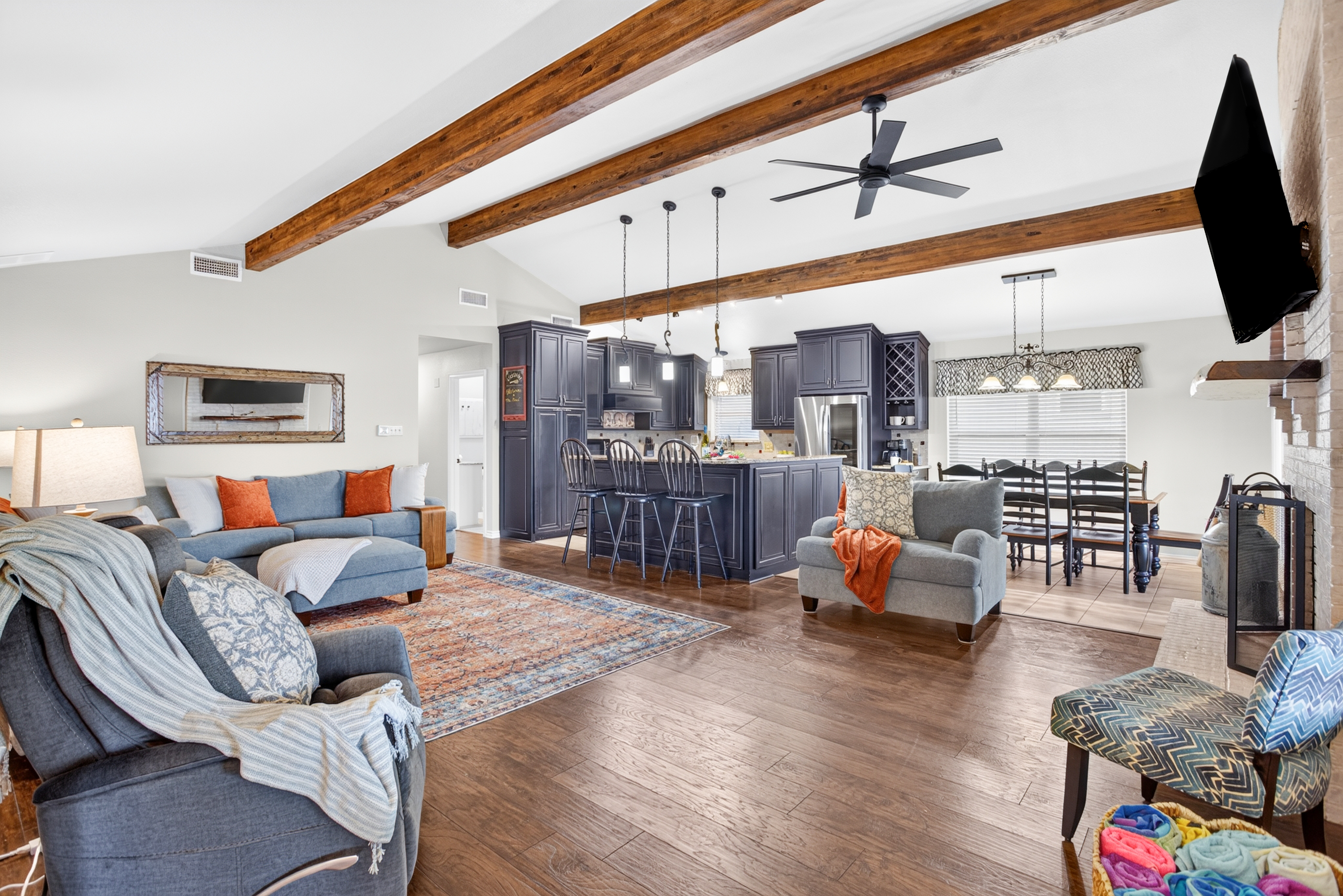 Spacious open living with wood beams, fireplace, and stylish kitchen