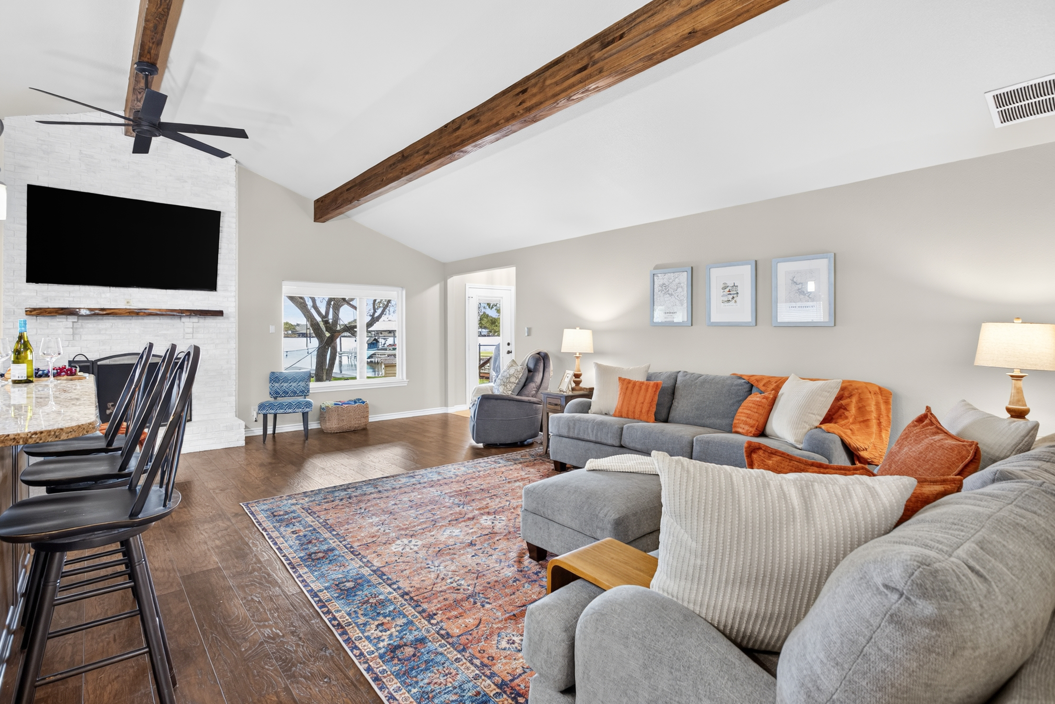 Spacious vaulted living room with cozy seating, beams, and big-screen TV