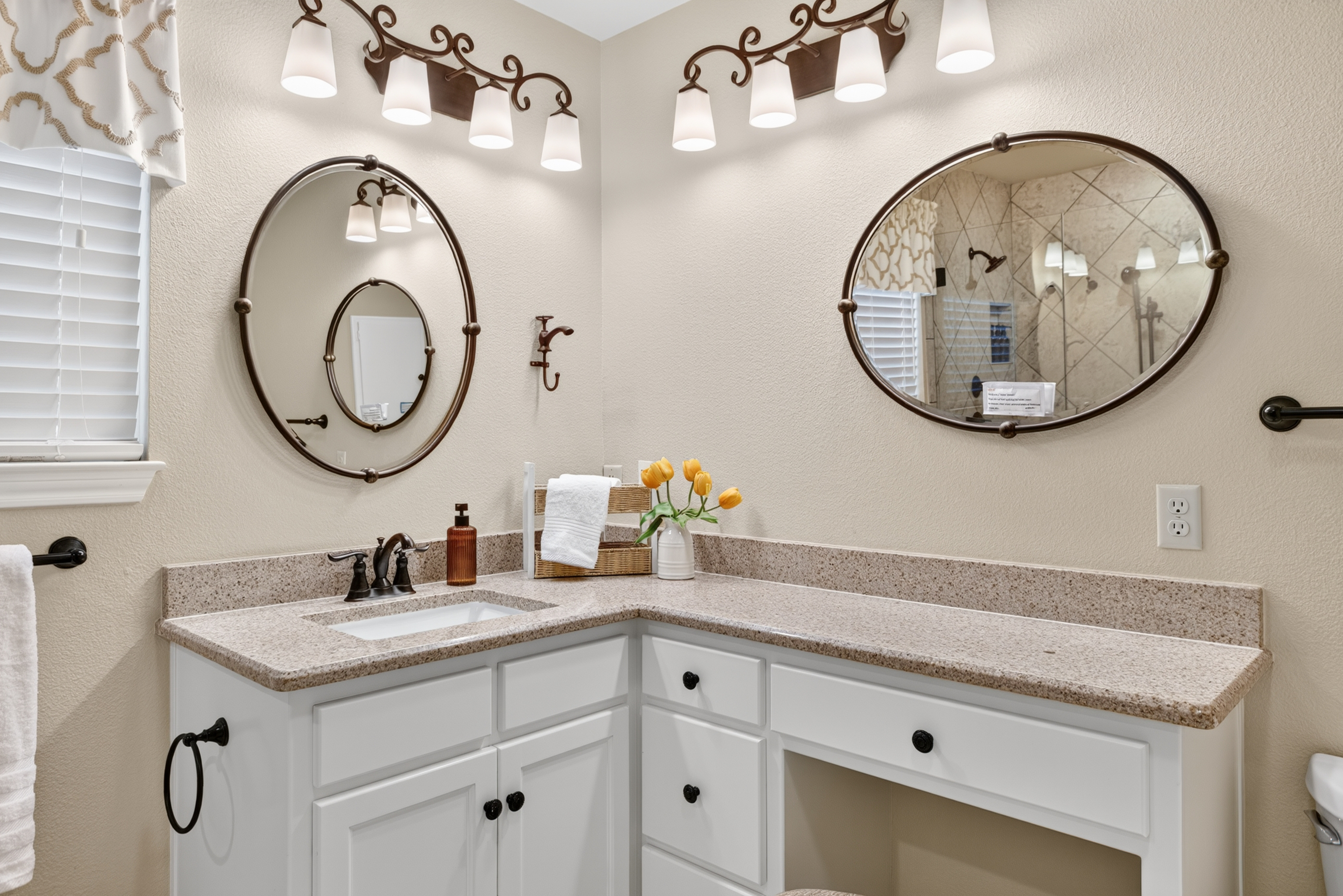 Bright bathroom with spacious vanity, elegant lighting, and stylish finishes