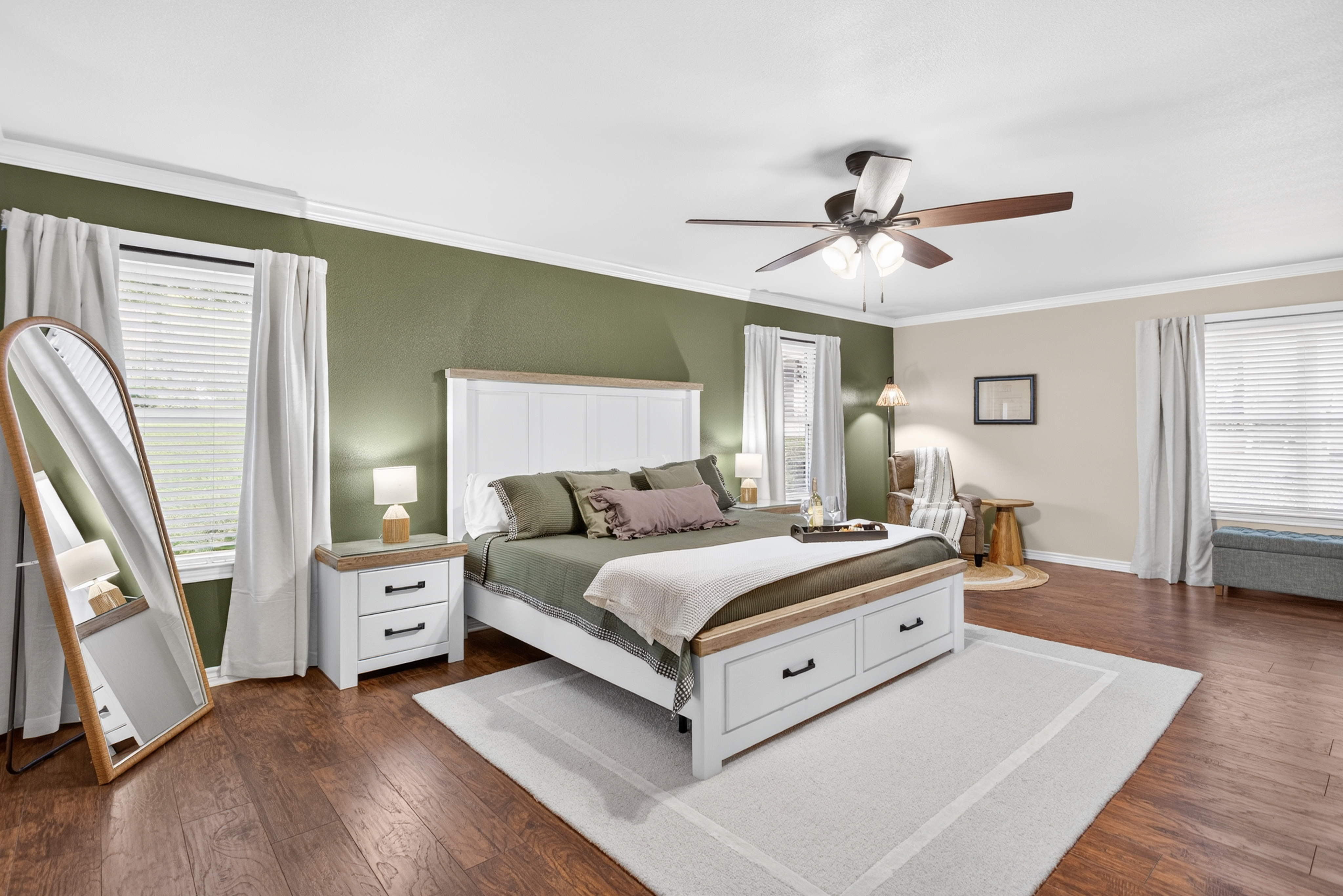 Spacious, stylish bedroom with cozy seating and abundant natural light